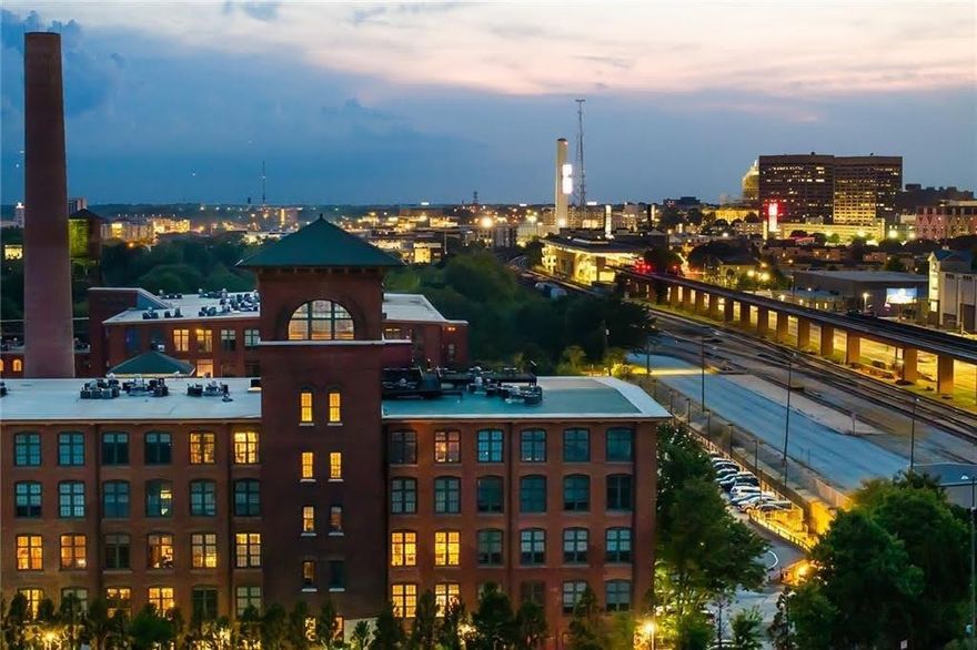 Experience authentic loft living from this breathtaking corner residence at Atlanta's most iconic address—The Stacks at Fulton Cotton Mill. Unit E324 is a rare offering, perfectly positioned to capture the soul of the city while enveloping you in unmatched industrial-chic luxury.

This premier 2-bedroom, 2-bathroom home is defined by its soaring 20-foot-plus ceilings, original 19th-century exposed brick, and massive, two-story industrial windows. Holding north-and-east-facing views, the space is flooded with natural light—from the soft glow of sunrise to the east to the inspiring city lights to the north. The expansive open-concept living area provides a dramatic backdrop for both grand entertaining and quiet relaxation. The gourmet kitchen flows seamlessly into a spacious combined dining and living area where the authentic rustic wooden beams frame the true centerpiece of the home: the view. Head up to the rooftop to be mesmerized by breathtaking, panoramic views of the downtown Atlanta skyline.

The Stacks Lofts are located in historic and vibrant Cabbagetown community. The property offers gated secure access to the 17-acre property and building.  Other amenities are redesigned outdoor common areas, dog walk, fireplace, firepit, seating, fitness center and olympic size saltwater pool.  The Loft Community is Located just steps from the buzz around the Atlanta BeltLine, the restaurants of Carroll Street, and minutes from Krog Street and Ponce City Market.  This unit comes with a rare dedicated parking spot.  Your new lifestyle awaits!