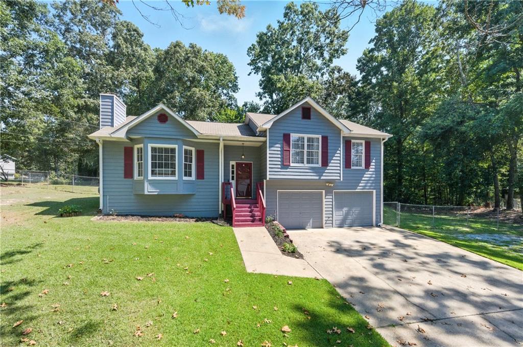 Rare find on almost 1/2 ACRE! One of the largest lots in the neighborhood and one of the larger floor plans! Newer carpet (1 year), interior painted throughout (including dark trim), newer luxury vinyl in both baths and kitchen! The adorable country kitchen has ample cabinet space and stainless steel appliances. The gas range/oven and dishwasher are under 1 year old. Newer fixtures throughout including toilets, lighting, switchplates, door hardware and more! Large primary bedroom with dressing area and walk-in closet. Large secondary bedrooms. Newer blinds and window treatments throughout including roman shades. The basement has great features, daylight in back and partially sheet rocked. This basement is clean and dry - maybe a gym or man pit? Oversized 2-car garage has room for a workshop and plenty of storage. The parking area can be HUGE if you have a boat, camper or work vehicle, this is for you! Huge sunny deck is rustic and so enjoyable with all-day sun and peaceful mornings and evenings. The back yard is fully fenced with a double-gate and a single gate. The HUGE outbuilding has electric and endless possibilities. Stored here are storm windows for all windows of the house (except the kitchen window). The neighborhood has NO HOA, it is friendly and quiet, convenient to Dallas, Cartersville and Acworth. Great new schools in the area too. Schedule your showing today, you won't be disappointed!