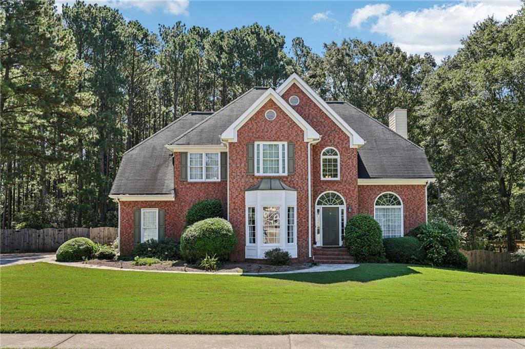 Spacious home on nearly an acre! Feel welcomed with a sweeping front lawn and mature landscaping. Step inside to find gorgeous hardwood floors flowing through the two-story entry and into the formal dining room. A versatile front flex room with built-ins is ideal as a formal living room or private office. The light-filled living room features built-ins and a cozy fireplace, opening seamlessly to the kitchen with a breakfast bar, granite counters, tile backsplash, wood floors, stainless steel appliances, butler’s pantry, and a charming bay-window breakfast nook. A convenient laundry room and half bath complete the main level. Upstairs, retreat to the oversized primary suite with a sitting area perfect for reading or movie nights. The spacious en-suite bath offers dual sinks, a soaking tub, separate shower, and a large walk-in closet. Three spacious secondary bedrooms and a full bath provide plenty of room for everyone! The finished basement includes a large flex room—perfect for a game room, media room, playroom, or hobby space—along with a full bathroom with dual showerheads and generous unfinished storage. Step outside to your private outdoor oasis: a fenced yard backing to woods, plus a two-level deck with a pergola-covered seating area above, a lower deck designed for grilling and entertaining, and a covered space with a patio slab. Don't miss your opportunity to tour this home today!