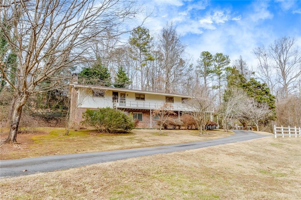 10 Acres! 10 Acres! LAND! LAND! Home features 4 bedrooms and 3 bathrooms nestled on a rare 10 ACRES parcel of land in Kennesaw GA! NO HOA and offers a rare combination of privacy, convenience, and opportunity. The possibilities are endless. Property is minutes from Kennesaw State University and I-75. Whether you are seeking for outdoor exploration, room to expand or a versatile property to fit your vision, this acreage is a perfect match.