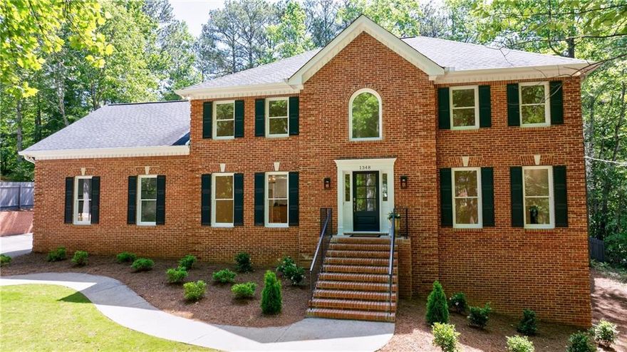 Presenting an exquisite 8-bedroom, 5.5-bathroom executive estate, masterfully constructed with four-sided brick and seamlessly blending timeless craftsmanship with sophisticated modern upgrades. Nestled on a private one-acre lot, free from HOA restrictions, this distinguished residence is captivated by a long beautiful driveway and wood fencing in the back around the pool, ensuring utmost privacy and exclusivity. The centerpiece of the meticulously landscaped grounds is a resort-style pool, an inviting oasis for relaxation or elegant gatherings.

Step inside to discover refined interiors, featuring gleaming white oak floors and freshly installed plush carpeting in the upper-level bedrooms, complemented by neutral-toned walls that exude understated elegance. The gourmet kitchen, a chef’s masterpiece, showcases lustrous quartz countertops, a professional-grade gas range with electric oven, an integrated microwave within the expansive island, a deep farmhouse sink, and a generous walk-in pantry. A custom-designed laundry room with stacked washer and dryer enhances daily convenience.

Each bathroom is a study in luxury, appointed with frameless glass showers. The main-level primary suite, a serene retreat, features a spa-inspired walk-in shower with dual heads and a rainfall feature, while the upper-level primary suite offers a double vanity and a freestanding soaking tub overlooking tranquil garden views. Dual primary suites, including one with direct pool access, provide unparalleled flexibility for multi-generational living or guest accommodations.

The finished lower level offers a versatile space for entertainment, complete with two additional bedrooms, a full bathroom, a custom wine cellar, and ample room for a home theater or fitness area. A stately fireplace anchors the open-concept main living area, ideal for sophisticated gatherings, while the expansive grounds ensure seclusion and serenity.

Strategically located minutes from premier dining, Truist Park, major highways, and within a 30-minute drive to the airport, this move-in-ready estate offers both convenience and prestige. Schedule a private tour to experience this architectural masterpiece. Owner/Agent.