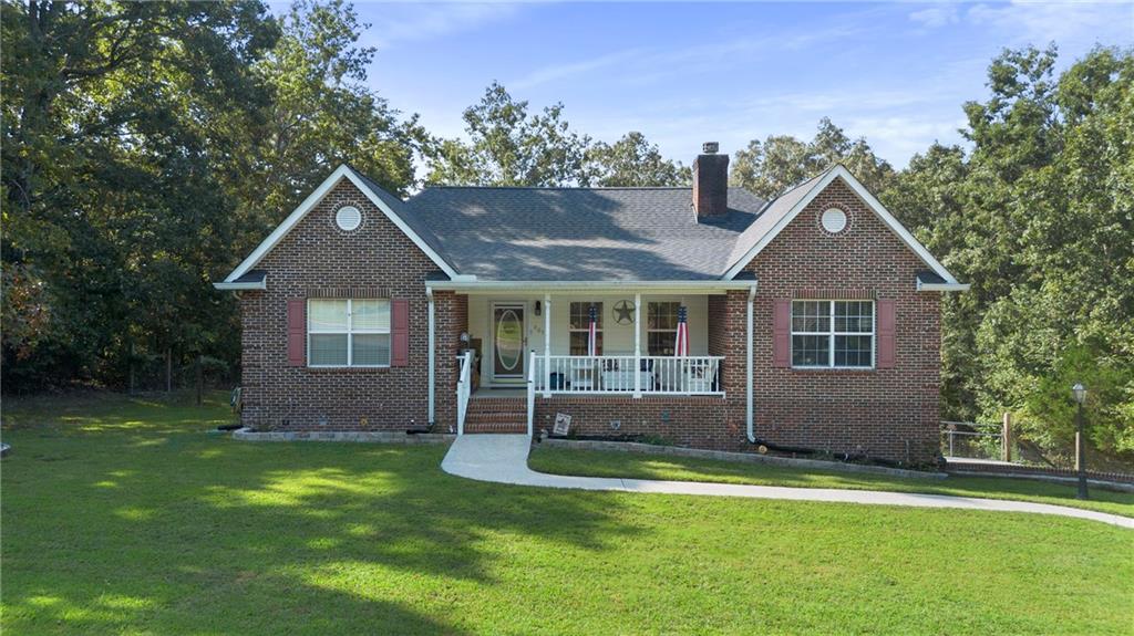 Welcome to your new home! This 4-bedroom, 2-bathroom brick home offers both comfort and character with recent updates and plenty of space inside and out. You are first greeted with a large front porch creating an inviting spot for rocking chairs and evening conversations. Inside, the living room, the vaulted ceiling sets the tone for the open layout. To the left, the primary suite features a double tray ceiling, walk-in closet, and a spacious bath complete with double vanity and jetted tub. Also off the living room, two additional bedrooms share the second full bath, with the laundry room nearby for convenience. Back through the living room, the dining room flows into the galley kitchen and breakfast nook, where a large multi-level deck awaits overlooking your private, wooded backyard, offering a peaceful setting for both everyday living and weekend gatherings. Downstairs, the finished basement adds flexibility with brand new flooring, a cozy den, and the fourth bedroom featuring a walk-in closet. The basement also includes a very large two-car garage with plenty of storage. With its 3/4 brick exterior, the home is low maintenance, while a roof replaced only two years ago provides peace of mind. Mature trees surround the property, creating strong curb appeal and a sense of privacy rarely found in a neighborhood setting. The sellers are also including a $2,000 flooring allowance for carpet, giving buyers the chance to personalize. This Rock Spring home blends thoughtful design, recent updates, and a peaceful lot, making it a place you'll enjoy for years to come.