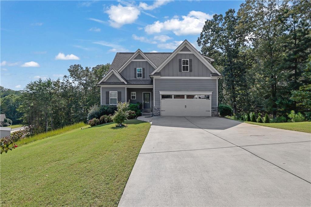 Come and see 99 Glen Oaks Dr in Dawsonville, a beautifully maintained 4-bedroom, 2.5-bath Traditional home with NO HOA. The open-concept layout is ideal for modern living, featuring a chef’s kitchen with stainless steel appliances, granite countertops, a subway tile backsplash, and an oversized island overlooking the spacious living room with a stone fireplace. Enjoy the private, fully fenced backyard from your back deck, perfect for quiet mornings or evening gatherings. This home also includes a full basement offering incredible storage or expansion potential. Set on a .62-acre lot with lovely curb appeal, this home blends comfort, space, and functionality in a peaceful setting.