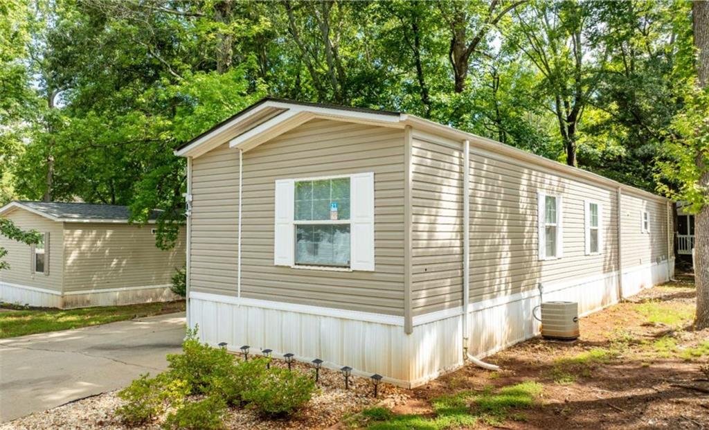 Fully renovated mobile home located in the sought-after city of Buford, just minutes from Lake Lanier and Margaritaville. This move-in ready home features a brand new roof (2024), new gutters and downspouts, new vinyl flooring, freshly painted kitchen cabinets, and all new appliances including stove, refrigerator, dishwasher, microwave, food disposal, washer and dryer. Both bathrooms have been remodeled. New lighting and ceiling fans throughout. Home includes a total of four closets plus a dedicated shoe closet in the main bathroom and a large closet in the living area. Spacious deck! Brand new metal shed stays with the property for added storage. Land lease is $802/month. Located in Countryside Village of Lake Lanier, a gated community offering resort-style amenities including a swimming pool, clubhouse, tennis court, basketball court, playground, dog park, and on-site church. Conveniently located near I-985, shopping, restaurants, and Lake Lanier. Affordable living in a prime location!