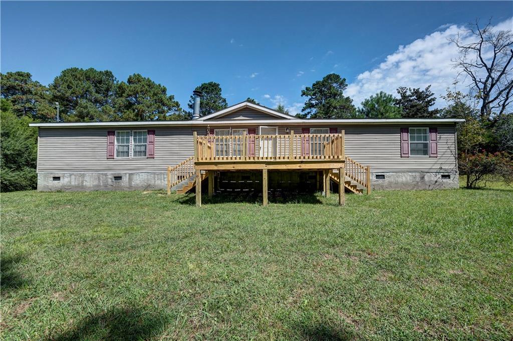 FIVE BEDROOMS ON MILLER FERRY - BIG SPACE, SMALL PRICE TAG TO MAKE IT YOUR OWN! This sprawling, 5-bedroom manufactured home on PERMANENT FOUNDATION is full of potential and offers an affordable option with room to S-P-R-E-A-D out. The FLEXIBLE FLOOR PLAN includes a welcoming layout with plenty of space for everyday living, as well as entertaining. From the BRAND NEW, EXPANSIVE FRONT PORCH with DUAL SIDE ACCESS, enter into the LIVING ROOM, which boasts a ROMANTIC FIREPLACE to create a warm ambiance on those crisp, Autumn nights. The DINING AREA is open to the living room, and leads into the MASSIVE, EAT-IN KITCHEN with CABINET AND COUNTER SPACE GALORE. The OWNER’S SUITE is tucked away from the other 4 bedrooms in a SPLIT-BEDROOM CONCEPT, and features a PRIVATE ENSUITE, complete with LARGE SOAKING TUB and SEPARATE SHOWER. Two of the secondary bedrooms flank a JACK-AND-JILL BATH, and the other two secondary bedrooms share a hall bath, which is conveniently positioned for guest use. This property is equipped with plenty of room to grow, making it a great fit for larger families, or anyone who simply values having extra space. Now is your chance to own a home to make your own that is affordable and ready for its next chapter. Welcome Home to 1653 Millers Ferry Road!