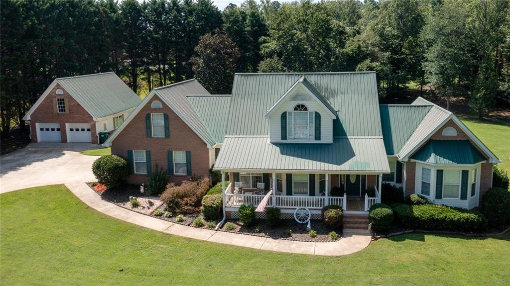 This Home Truly Checks All the Boxes!
From the moment you arrive, you'll be welcomed by a charming rocking chair front porch—perfect for relaxing evenings. Step inside to find an oversized family room featuring a cozy fireplace and gleaming hardwood floors, ideal for both entertaining and everyday living.
The heart of the home is the kitchen, beautifully appointed with granite countertops, a large island, breakfast bar, beverage cooler, and a spacious dining area just off the kitchen—perfect for casual meals or formal gatherings. A convenient half bath is also located on the main level.
The main-level master suite offers ultimate comfort with his and hers walk-in closets and a luxurious master bath featuring dual vanities, a separate soaking tub, and a walk-in shower.
Upstairs, you'll find three additional bedrooms, a full bath, and a huge bonus room with the option for a private second entrance from the garage—perfect for guests, a home office, or in-law suite.
The full finished basement adds even more living space with a full bathroom, generous storage, a living area, and flexible space for a home gym, media room, or hobby area. Additional features include a gas tankless water heater for efficiency and comfort.
Step into the enclosed back sunroom and prepare to be amazed—your own resort-style backyard oasis awaits! Enjoy a heated saltwater pool and hot tub, a large covered cabana with a custom TV cabinet and ceiling fan, perfect for watching your favorite show or game from the comfort of the spa.
There's plenty of space for all your toys and tools with a 2-car attached garage, plus an additional detached 2-car garage complete with workshop space and unfinished storage above.
All of this is nestled on a sprawling 2.61-acre private lot that includes a basketball court and a fenced dog run—this home truly has something for everyone!