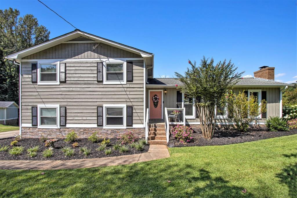 Charming Split Level on a Cul-de-Sac in Acworth! Just minutes from KSU, Shopping, Award-Winning Restaurants, and Interstates 75/575. Curb Appeal shines with a Grassy Front Yard, Gorgeous Landscaping, and Summer-Blooming Crepe Myrtles. Step inside to find Dark Hardwood Floors and an Open Main Level featuring a Brick Fireside Living Room. The Dining Area is perfectly placed by sun-filled windows, while the Kitchen offers a Large Breakfast Bar, Stone Countertops, Butcher Block Counter on the Island, Classic Subway Tile Backsplash, and White Cabinets. A Vaulted Ceiling Sunroom adds flexible living space ideal for a Home Office, Playroom, or cozy Sitting Room. Enjoy morning coffee here or step out to the Private Screened-In Porch, perfect for Al Fresco Dining overlooking the Large Fenced Backyard. Upstairs, the Primary Bedroom boasts an Updated Ensuite with a Stone Vanity and Oversized Glass Shower. Two Additional Bedrooms share a Hall Bath with a Tub/Shower Combo. The Backyard is a True Paradise Flat and Fully Fenced with plenty of room for Play, Gardening, and Entertaining, plus year-round enjoyment on the Screened-In Porch. A 15-Foot Blueberry Bush, which produced over 50 lbs. of blueberries this year, is the centerpiece of the garden and a true delight for nature lovers. Additional highlights include a Two-Car Garage with Workbench included, offering storage and workspace for hobbies, projects, or organization. Nestled in a Quiet, Charming Community, this home offers unbeatable access to Kennesaw, Woodstock, Acworth, Cartersville, and East Cobb. Minutes from Lake Allatoona and the peaceful Clark Lake, you'll enjoy Tranquil Views and Lake Life just around the corner. With a Prime Location near the Cobb County line, you'll have the Best of Both Worlds convenient to both Cobb and Cherokee Counties while tucked away from busy roads in the tight-knit Cherokee South neighborhood. Don't miss your chance to call this Acworth treasure your next home!