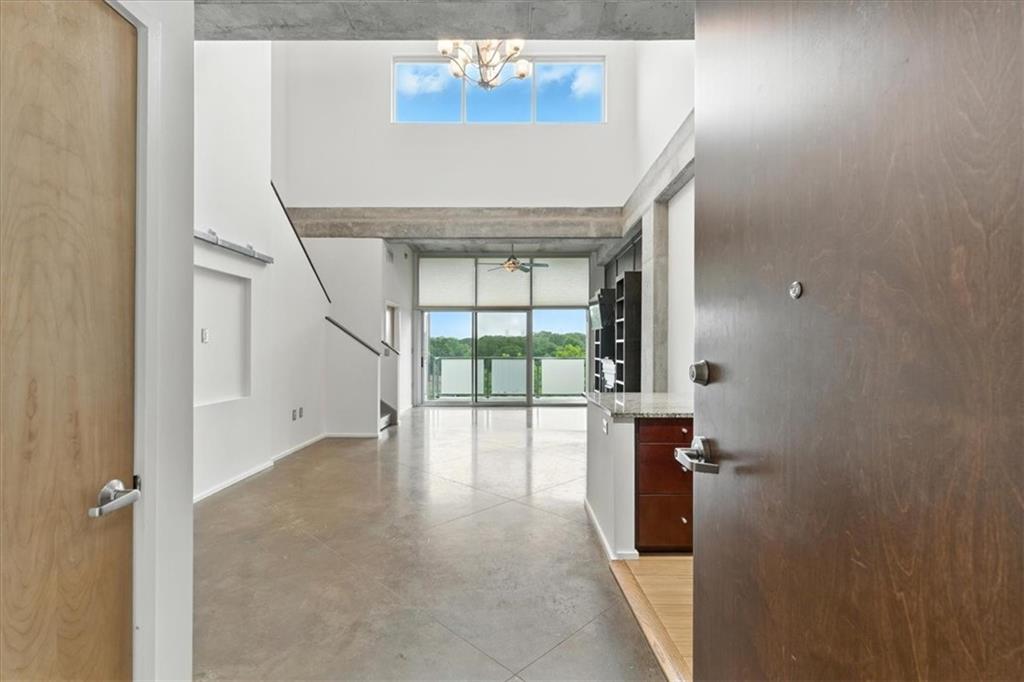Fantastic Loft! Terrific Top Floor with amazing tree lined view at AZ2 Lofts. Great open space with soaring 22ft ceiling, scored and painted cement floor with Hunter Douglas window treatment throughout. Beautiful kitchen with glass tile backsplash, granite countertops with breakfast bar, European style cabinetry, Stainless appliances all open to living/dining area, leading to a covered full length balcony. Retreat to the oversized primary suite complete with a custom walk-in closet and a luxurious en-suite bath, featuring a Japanese soaking tub, oversize walk-in tiled shower with dual action heads and elegant finishes. Step out onto your private, sizable roof-top terrace from the primary suite — an ideal spot for morning coffee or evening relaxation. Two additional rooms on main, with custom built closets for bedrooms or office with a connected full bathroom. Unit has 2 assigned parking spots, Storage unit and a Cubby space for more storage. Solid amenities - enjoy a workout in the deluxe gym, summer days relaxing by one of the two pools, one being a lap pool and clubhouse. Located just minutes from Candler Park, Kirkwood, and the City of Decatur, you’ll love the convenience of InTown living with vibrant dining, shopping, and parks nearby.