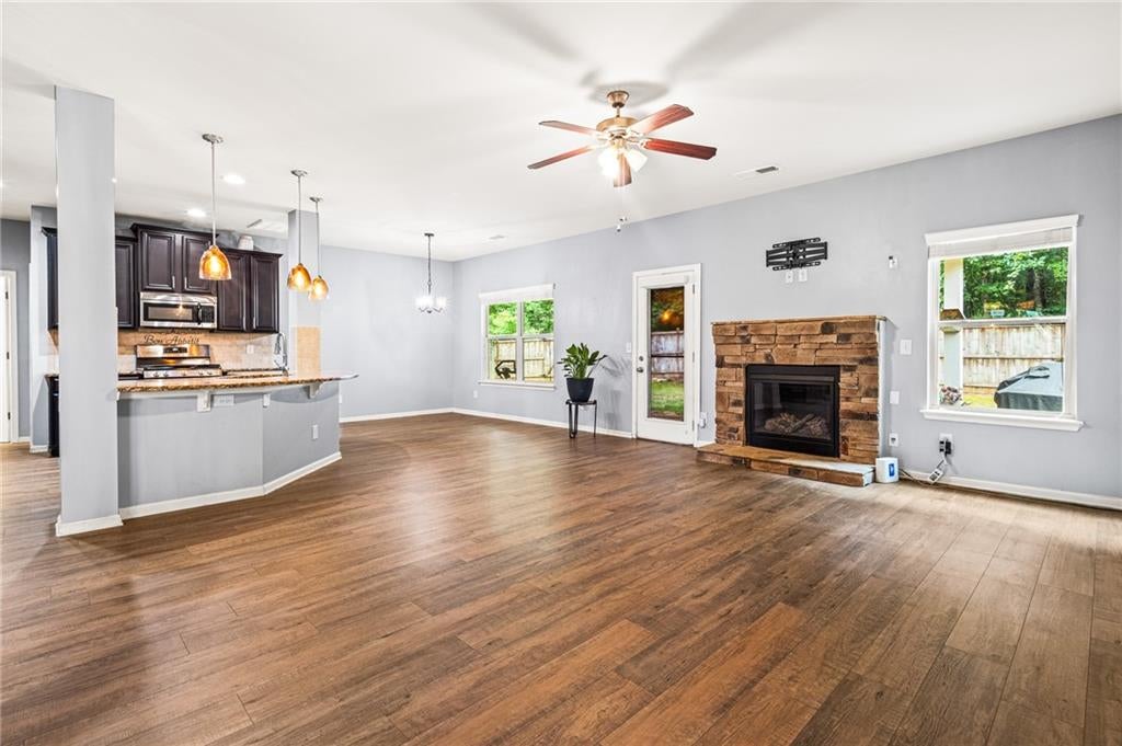 Living space featuring wood-finish flooring, dark accent wall, white ceiling, and a decorative ceiling light fixture