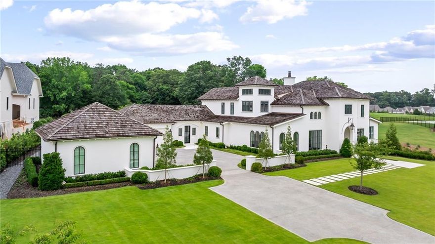 Steps from Kennesaw Mountain hiking trails, this extraordinary Country French Modern estate—designed by renowned architect Linda MacArthur and completed in 2022—offers refined living in a peaceful natural setting. Every detail of this thoughtfully executed home reflects the highest caliber of design and craftsmanship, from the Brava Cedar Shake roof to the seamless indoor-outdoor flow.

Inside, elegant yet livable spaces unfold across all three levels, with gracious living rooms on each floor and sweeping views to the pool, gardens, and surrounding greenery. The main kitchen is complemented by a fully equipped scullery, ideal for effortless entertaining, along with a sophisticated bar that connects the kitchen and dining room.

Resort-style amenities include a stunning pool, whole-house water filtration system, generator, and smartly integrated luxury finishes throughout. A rare opportunity to own a modern architectural gem in a private, nature-rich setting.