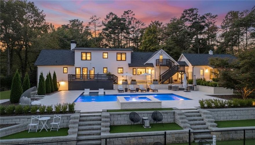 Welcome to an EXTRAORDINARY PRIVATE RESORT STYLE RESIDENCE in the heart of Alpharetta. An impeccably TWO STORY RANCH estate resting on MORE THAN TWO FULLY FENCED AND GATED ACRES. Recently transformed with seven figure improvements, this residence offers the epitome of refined living with every detail designed for comfort, style, and peace of mind. From the NEW ROOF, septic system, HVAC units, windows, and dual hot water tanks, to the exquisite finishes throughout, no detail has been overlooked. A breezeway connects to the three-car carriage-style garage, while the inviting rocking chair front porch with dual ceiling fans sets the tone for relaxed elegance. The property itself is a sanctuary, complete with landscape lighting, seasonal foliage, and a wooded backdrop that frames the heated pool, spa, and professional-grade lighted tennis and pickleball courts. RATED FOR PROFESSIONAL PLAY! Inside, the home’s thoughtful in-law floor plan offers remarkable flexibility, with a primary suite on the main level and an additional primary upstairs. Perfect for guests or multi-generational living. Each bedroom is a private en-suite featuring spa-inspired baths, including one with a striking concrete free-standing soaking tub. The main level boasts a family room anchored by a floor-to-ceiling brick fireplace with direct access to the expansive deck, a formal dining room, and a chic butler’s pantry with sink. The eat-in kitchen is a showpiece of design with stainless steel appliances, vent hood, glass subway tile backsplash, floating shelves, and a charming dining nook overlooking the pool and patio. A laundry room, half bath, and built-in desk/workspace room complete the main level with ease. The FINISHED TERRACE LEVEL expands the living space, offering another bedroom, bonus rooms, two spa-like baths, and even a SECOND KITCHEN ideal for entertaining or extended stays. The seamless indoor-outdoor flow of this home is unparalleled, blending sophistication with functionality at every turn. Minutes from Avalon, Downtown Alpharetta, the Greenway, premier golf courses, healthcare, award-winning schools, and year-round dining and entertainment. This estate is more than a home, it’s a lifestyle. Prepare to be wowed by a residence where luxury meets everyday living!