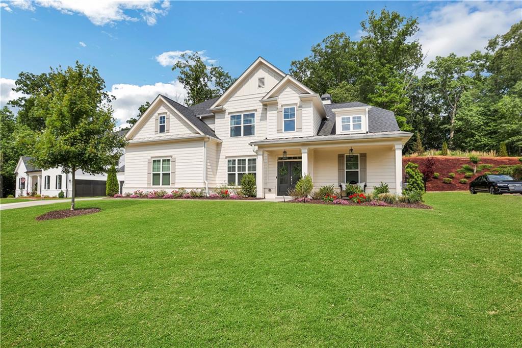 Welcome to a Farmhouse home with mid-century modern flair quietly nestled in the highly sought after St. Michael’s Bay gated lakeside subdivision on Lake Lanier. This well-appointed 5 bedroom (master-on-main), 4.5 bath, 3-car garage home is situated on 0.65 acres with private lush natural woods. There are many inviting architectural details including covered porch entry, hardiboard & brick exterior, formal dining/sitting room, 2-story family great room, breakfast room, crown molding, hardwood floors & stairs, custom closets & built-ins, designer lighting, two-tone paint, extended covered patio and much more! Large primary en-suite with sitting area, spa-like bath with soaking tub, walk-in shower, his & her vanities, and customized walk-in closet. Entertain in the gourmet kitchen w/ stainless gas appliances, white cabinetry with custom statement wood vent hood and large island with exotic granite which looks onto the Family Great Room with 75” OLED Samsung TV and surround sound system and stately remote controlled gas fireplace. Be comfortable and secure with the full security system to include audio/video recording and camera doorbell, ample additional storage areas, flexible spaces to be what you need it to be (office, gym, studio, playroom, WFH, etc.), whole-house automatic gas generator for emergency power, view-fenced yard, low maintenance landscape w/ garden beds and full yard irrigation. This private community includes a community dock for day-use of your own boat or fishing, resort pool, tennis/pickleball, play areas, fitness, clubhouse, and scenic nature trails that follow along the lake. Easy access to GA-400, exceptional Forsyth County schools, close to grocery, shopping, and full-service marinas. Please use provided shoe covers.