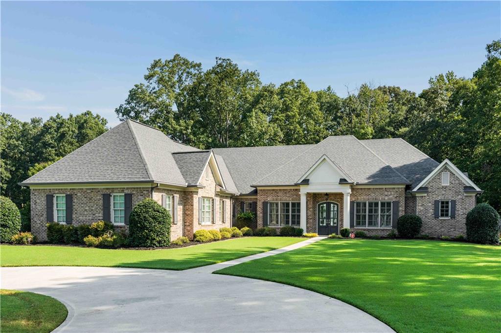 Welcome to 345 Sidney Lane - a single-story, custom-built, all-brick ranch where timeless craftsmanship meets relaxed coastal luxury. Set on a picturesque 1.36-acre corner lot in one of Fayetteville's most sought-after school districts, this 5,298 sq.ft. residence (3940 sq.ft. of living space, 1,000 sq. ft. of garage, and 300 sq.ft. of screened porch) offers open, airy living with meticulous attention to detail. At the heart of the home, the inviting great room showcases custom built-in bookshelves and a cozy fireplace, creating a warm and welcoming space perfect for relaxing with a book or gathering for a movie night. The great room opens seamlessly to an expansive screened-in porch with breathtaking wooded views - the perfect tranquil retreat. Just steps away, the chef's kitchen is designed for effortless entertaining, featuring a statement-making center island, an expansive breakfast bar, and a versatile dining area ideal for both everyday meals and casual gatherings. A keeping room provides a cozy spot to unwind alongside the kitchen, while the walk-in pantry ensures everything stays beautifully organized. Four spacious bedrooms each boast a private ensuite bath, offering comfort and privacy for family and guests. Throughout the home, custom cabinetry blends elegance with function, while sunlight floods the expansive living areas, highlighting the easy flow and sophisticated coastal-inspired finishes. An oversized, three-car garage with pristine epoxy flooring and custom, built in cabinets completes this exceptional home, providing ample space for vehicles, hobbies, and storage.