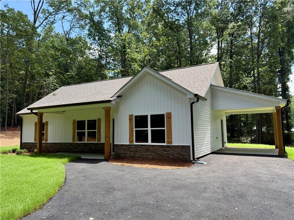 NEW CONSTRUCTION RANCH ON 3 QUIET ACRES – NO SUBDIVISION OR HOA!!! Act now for a FREE appraisal and $3,000 in incentives with our preferred lender. Conditions apply. See listing agent for details.
This stepless ranch home is under construction on a serene 3.098-acre lot -- offering the perfect blend of privacy and convenience. Conveniently located north of Buchanan off of Hwy 27 going towards Cedartown. Featuring 3 bedrooms and 2 full bathrooms, the home showcases an open layout with vaulted ceilings in the main living and dining areas for a spacious, airy feel.
There's still time for buyers to add their own personal touches! Contact the listing agent today! The kitchen is designed with granite countertops, a counter-height bar, and a stainless steel appliance package including an electric range, built-in microwave, and dishwasher. The split-bedroom layout provides privacy, and the primary suite features a walk-in closet and a bathroom with double vanities, framed mirrors, granite countertops, and a stand-up shower.
The two secondary bedrooms are generously sized and share a full bathroom with a granite vanity and a tub/shower combo. Ceiling fans are included in the living room and primary bedroom. Outside, the home will be finished in low-maintenance vinyl siding with a stone water table for added curb appeal.
This floor plan includes an attached carport. Tract 2 is also available and being marketed without the carport in another listing.
Don’t miss this opportunity to customize your dream home in a peaceful country setting! ***Photos are of a home similar to the one being constructed, not of the actual subject property.***Please note that the property is in the VERY EARLY stages of construction/clearing.***