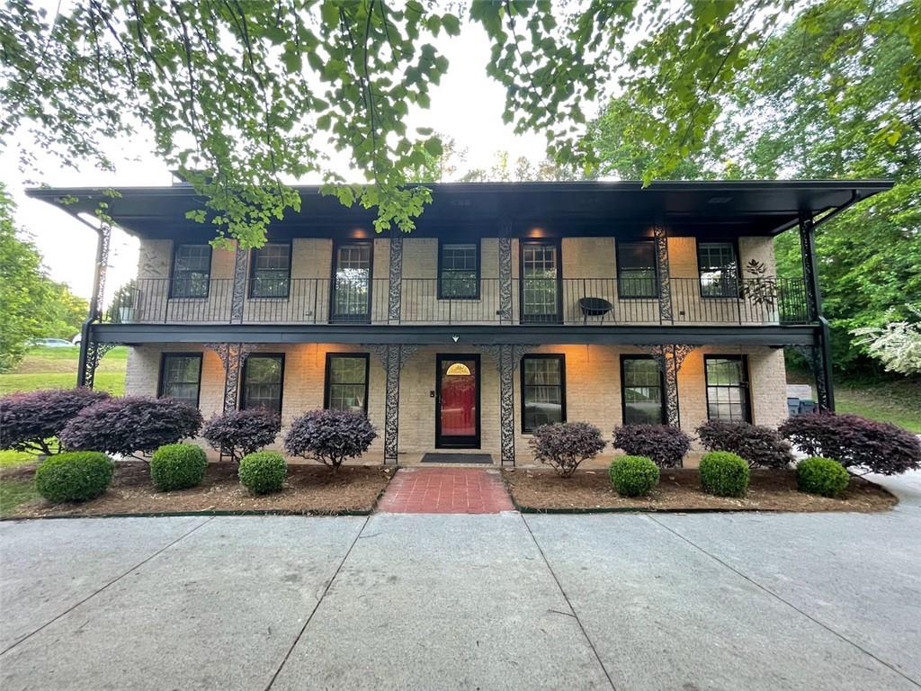 **2.99% VA LOAN ASSUMABLE INTEREST RATE** This gorgeous Creole & Victorian influenced home in the desirable Pleasant Acres subdivision, offers 4 spacious bedrooms, 2.5 baths and generous living space. The stacked and columned porches give you fresh air space as well as shade to enjoy. As you approach, you'll be captivated by the enormous front yard and the convenience of a large circular driveway. Step inside to find an absolutely perfect floorplan that radiates natural light throughout. The heart of this home is the kitchen, featuring a quaint island, updated appliances and overlooks the open concept living space. Adjacent to the kitchen, a lovely dining room space boasts beautiful floor to ceiling sliding glass doors, creating an inviting atmosphere for meals. The main floor showcases beautiful hardwood floors and a huge living room complete with a cozy gas-burning fireplace, ideal for family gatherings or quiet evenings at home. Step outside to the gorgeous balcony, an ideal spot for morning coffee or evening relaxation, overlooking the expansive 1.08-acre lot. The sale also includes 7044 Pleasant Dr, providing the potential for an additional dwelling unit. All of this and more, just 15 minutes from downtown Atlanta, combining suburban tranquility with city convenience. Don’t miss out on this beautiful home – it won’t last long!