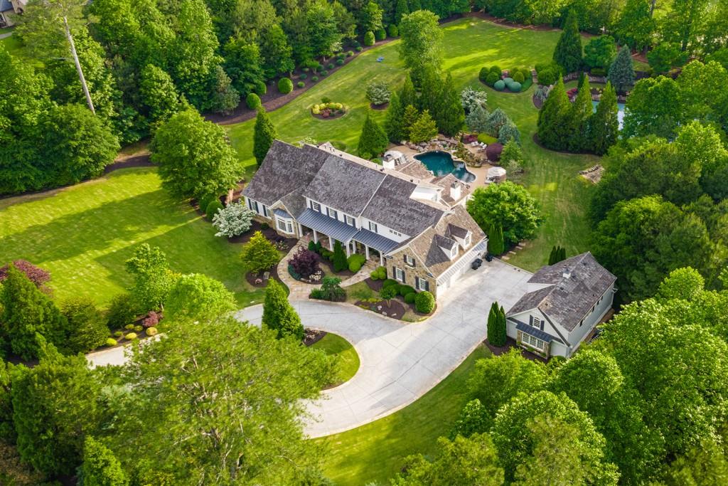 Experience resort living right in your backyard on this exquisite Milton estate on almost 4 acres! Beautiful, rolling green hills surround the heated, saltwater pool and spa with soothing rock waterfall, the tennis courts with lights and custom rock seating and the leveled sports field which is perfect for anything from croquet to baseball. Gated drive opens to circular driveway and curves to six car garages. Separate guest house is fully appointed with kitchen, bedroom, elevator shaft, bedroom/bath and laundry room. Owner's suite on main floorplan with stunning chef's kitchen featuring copper sink, 2 dishwashers, built-in Sub Zero refrigerator, Wolf suite of appliances (microwave, range with gas cooktop and double ovens, warming drawer), huge hidden walk-in pantry, Butler's pantry with wet bar/copper sink, custom cabinet vented hood, enormous island. Luxury custom finishes accent the home from to bottom and include stack stone fireplaces/arches, shiplap, wainscoting, tongue & groove wood ceilings, 10' ceilings on each level, wood beams, vaulted ceilings in several bedrooms and rooms. Finished terrace level features game room, family room, fireside sitting room, home gym, wine cellar and full second kitchen in addition to a large guest suite. Upper level complete with four large, full bedroom suites - each with large bathroom and separate living space.