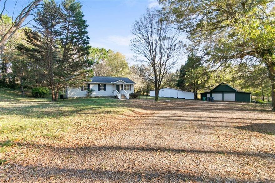 Welcome home to this charming and completely renovated 3-bedroom, 2-bath ranch set on a spacious lot with mature trees and plenty of privacy. Step inside to find a bright, open floor plan featuring new flooring, fresh paint, and a stylish kitchen complete with stainless-steel appliances, white cabinetry, and subway tile backsplash. The natural light and neutral palette create a clean, modern feel that’s ready for your personal touch.

Enjoy peaceful mornings or relaxed evenings on the new back deck overlooking the wooded backyard, perfect for entertaining or unwinding outdoors. The property also has two large outbuildings (including a detached 2-car garage), ideal for a workshop, extra storage, or hobbies. With thoughtful updates throughout and a convenient location close to downtown Woodstock, this move-in-ready home offers the perfect blend of comfort, functionality, and quiet charm.