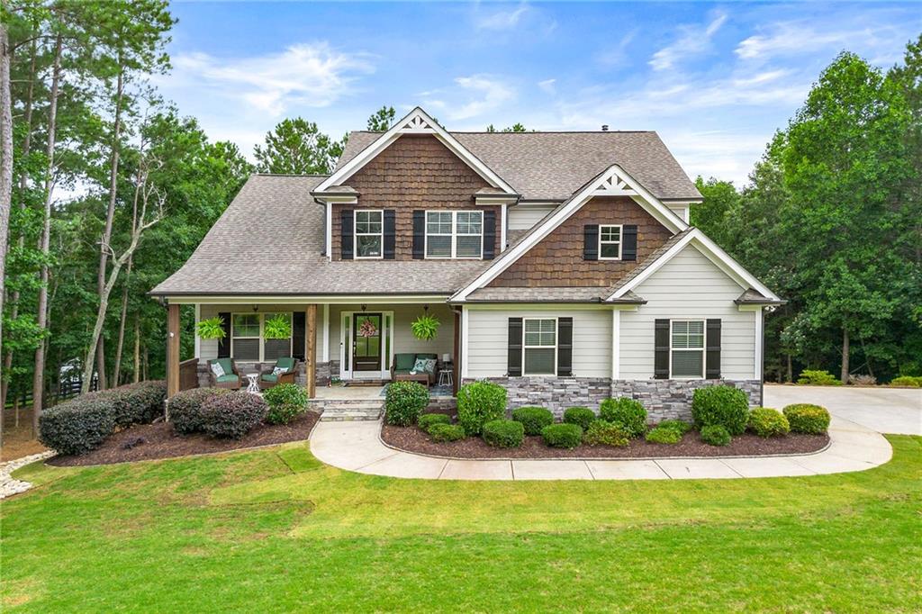 Welcome home to this Very well maintained home on a beautiful large serene private lot. Covered front porch welcomes you and is a great place for sitting outside with your morning cup of joe. Built in 2018, homeowners have just installed new LVP throughout the main floor and new carpet in all bedrooms. Freshly painted interior. This beautiful Home features an open floor plan with large kitchen open to Great Room and breakfast area. Kitchen features large eat at island with sink. Plenty of cabinet and counter space. Walk in pantry and stainless appliances. 2 story great room features a stone fireplace with extra trim work. Separate dining room could also be used as an office. Primary ensuite on main floor with new paint and carpet. Primary bath features dual sink vanity and separate garden tub and shower. Large walk in closet. Upstairs feature 3 more bedroom and 2 full baths. Large unfinished basement is stubbed for a bath. Home is minutes to Riverstone shopping, dining, movie theater. Downtown Canton features weekly farmers markets as well as great dining and shopping.