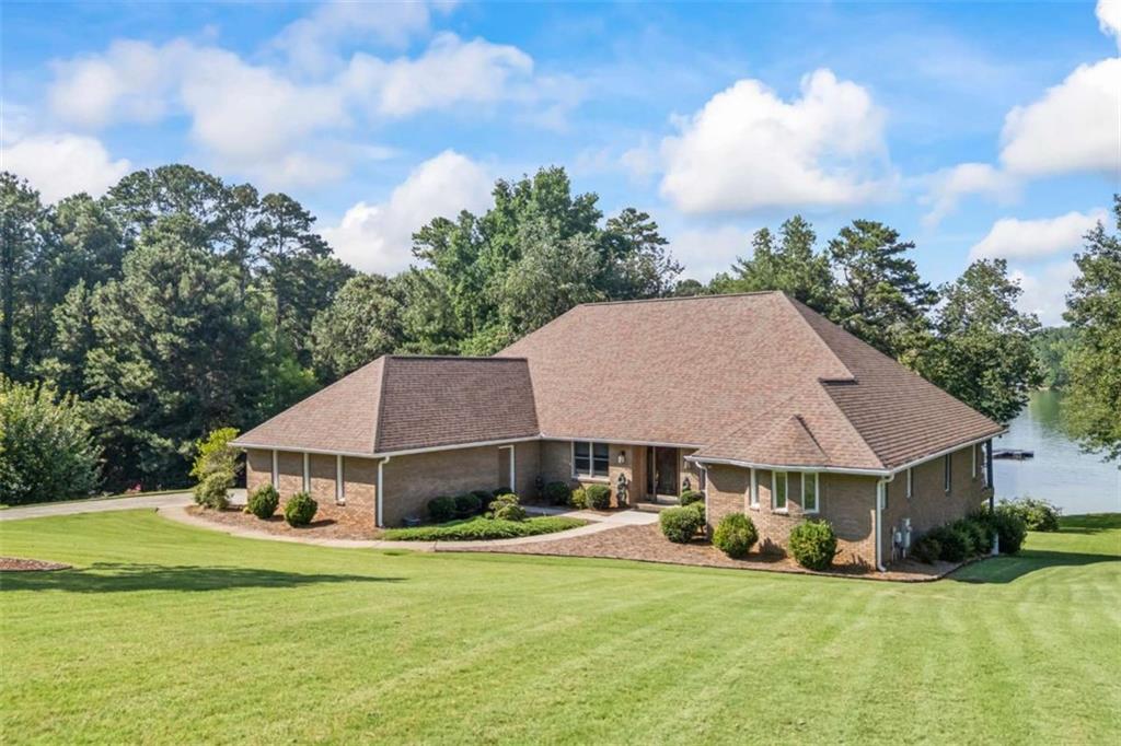 Lakefront living in sought-after Cherokee Forrest. This impeccably maintained, 4-sided brick residence offers over 4,500 square feet of living space on a gently sloping 0.67-acre cul-de-sac lot with direct access to Lake Lanier. A private single-slip dock in deep water is just steps away, and a composite deck spans the back of the home, providing peaceful, uninterrupted lake views. The 4BR/2.2BA split bedroom floor plan features a spacious primary suite with water views, while the terrace level includes a finished family room, bedroom, full bath, and a workshop-all with walk-out access to a lake-facing patio. Recent updates include a new roof and composite decking. Located in one of the area's most desirable lakefront neighborhoods, Cherokee Forrest offers community amenities including a pool, tennis courts, pickleball, playground, and pavilion.