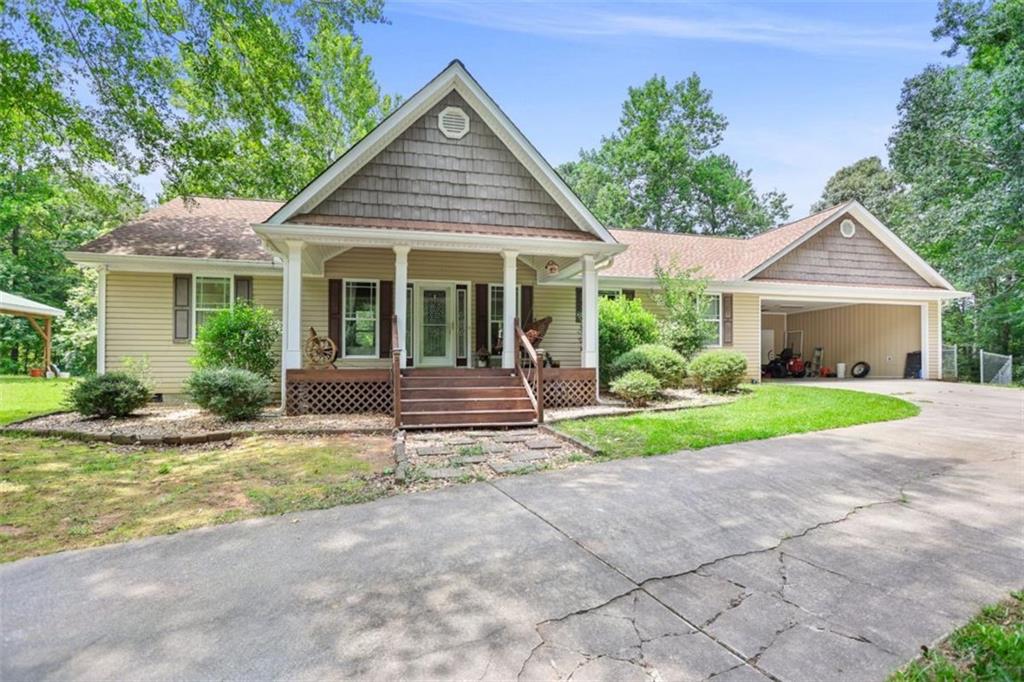 Welcome to your own private retreat-tucked away on 4.74 acres in sought after Heard County. A wide front porch welcomes you with room to relax and enjoy quiet mornings. Inside, the thoughtfully designed layout features granite countertops, a walk-in pantry, and a generous mudroom just off the garage-perfect for busy days and everyday functionality. The oversized primary suite offers a true escape with a walk-in closet and a private bath designed for comfort and ease. The back deck is off the kitchen overlooking the fenced backyard and provides plenty of room for entertaining! Downstairs, a partially finished basement provides endless options-whether you need extra living space, a home office, media room, gym, or guest suite. Additional features include an attached garage, detached carport, and a 24x40 powered workshop-ideal for hobbies, storage, or larger projects. Set in a peaceful, established area known for its strong sense of community and top-rated schools, this property blends comfort, space, and rural charm. Don't miss the opportunity to make it yours!!