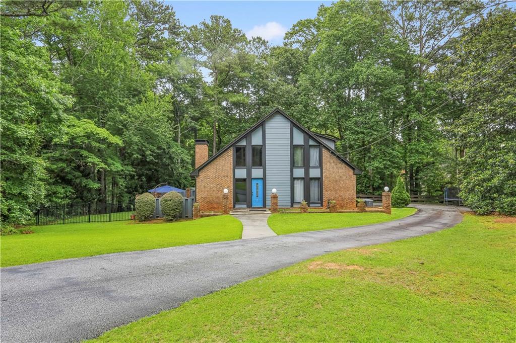Mid-Century Elegance: Dream Lifestyle
Welcome to 1605 Saint Tropez Way, your personal sanctuary nestled in this idyllic Sandy Springs' neighborhood. This exceptional Mid-Century retreat is more than just a home—it's a lifestyle. Perfectly situated adjacent to the Chattahoochee River National Recreation Area and just a stone's throw from Dunwoody, Roswell, and Avalon, 28 minutes from Midtown Atlanta. This location effortlessly combines serene seclusion of the suburbs with easy access to all that Atlanta has to offer.
The essence of timeless mid-century architecture, set on a sprawling 1.4-acre corner lot that promises privacy and tranquility. The lush wooded surroundings offer a peaceful escape from the hustle and bustle of city life.
Greeted by a gracefully curved driveway with side entry 2 car garage and ample parking welcomes you home. As you approach, the home's striking exterior—with its steep gables and decorative half-timbering—sets the tone for the storybook charm that awaits inside.
Descend the stairs into an expansive two-story living area, a masterpiece of design featuring soaring ceilings, beautiful wood beams, and a stunning brick fireplace. The wall of windows floods the space with natural light, while a charming catwalk along the second level adds a unique architectural touch. The rich wood accents and retro flair of the 1960s bar, complete with PELLA accordion shutters, create an inviting atmosphere perfect for both intimate family moments and grand social gatherings. Below the kitchen level you will find a huge basement for storage and a flex space or workshop. This space is well lit and has been waterproofed and radon remediated.
The seamless flow from living to dining, entertainment spaces, and private patio next to a park like wooded area all your own. This home is an entertainer's dream. The serene wooded backdrop offers the ultimate sanctuary for morning coffee or leisurely evening strolls.
Located in one of Atlanta's most coveted neighborhoods, you'll enjoy the best of both worlds—just moments from fine dining, boutique shopping, and top-rated schools, yet feeling worlds away in your serene retreat. Recent upgrades by the current owners, including a new HVAC system, hardwood floors upstairs, a generator, and radon remediation system, ensure you can move in with ease and personalize this home to your taste. You will be amazed.
1605 Saint Tropez Way isn't just a house; it's a gateway to a lifestyle of zen retreat and timeless elegance. This rare opportunity to own a piece of classic Atlanta charm won't last long. Schedule your private tour today and begin your next chapter in this dream home.