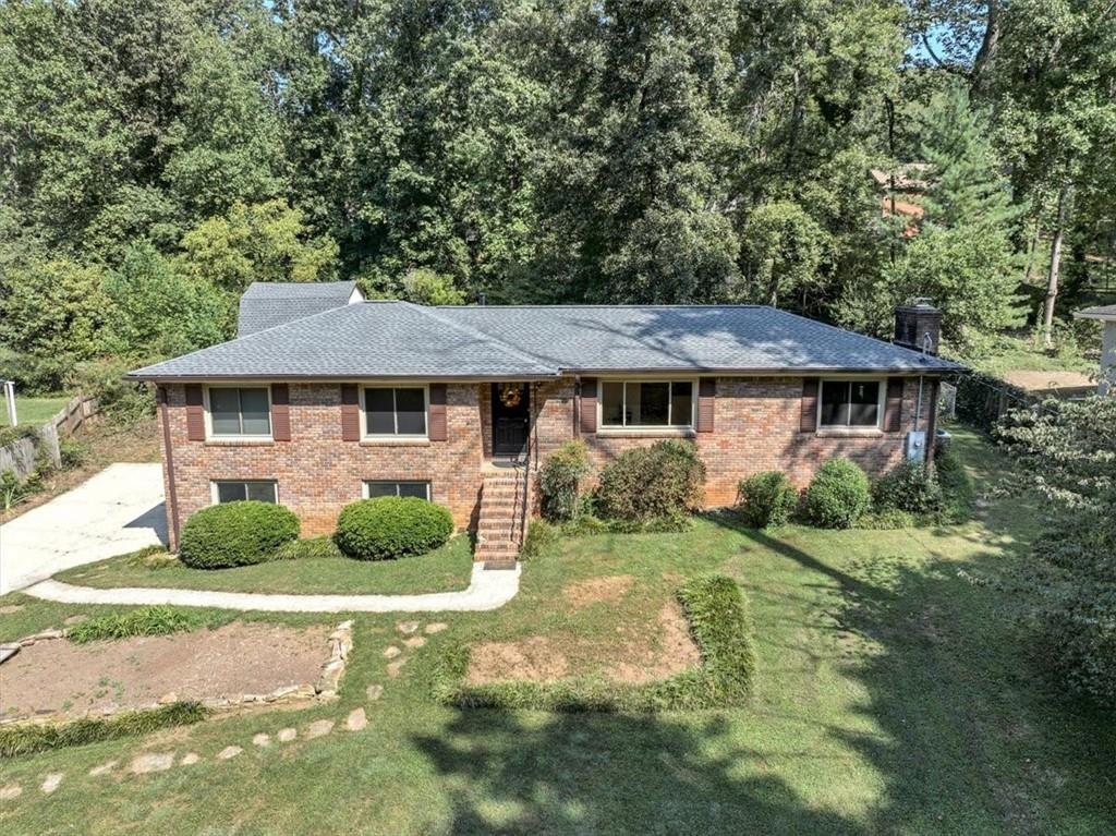 Charming 4-bedroom, 2-bath ranch home on a basement/garage is ready for your personal touch! This four-sided brick home has been meticulously maintained over the years and is located in the Sprayberry High School district.
The home features original and reclaimed hardwood floors with abundant natural light throughout. The living room includes a large, original brick wood fireplace, recessed lighting, and French doors leading to the fenced backyard. Never be out of the conversation with the home's open concept. The kitchen is open to both the family room and the living room.
The property boasts mature hardwoods, irises, lilies, and blackberry bushes, creating a beautifully landscaped setting. Additionally, a 16x16 storage shed is included, and the seller has reinforced the loft for extra storage space.