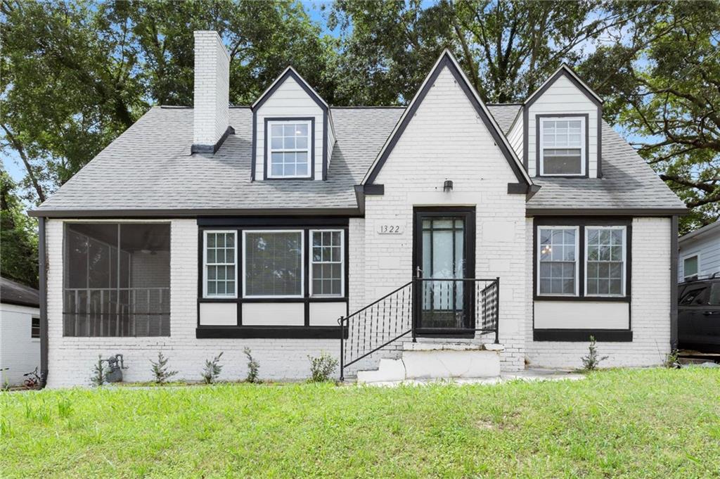 White brick exterior with black trim accents and a contrasting gray roof