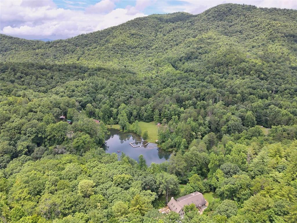 Amazing opportunity to own a large acreage track in Rabun County!  Own your place among the Blue Ridge Mountains as a personal retreat, investor  or camp operator. Tucked away among scenic breathtaking views with ridgelines, mountaintops, rolling hills and luscious valleys, there are plenty of places to connect with nature in any direction that you walk, camp, or hike. Horseback riding, fishing, hunting, photography, swimming, camping, hiking, bird watching, waterfalls to visit, nature trails to hike, a pristine lake, roaring creeks to explore & much more. It's so beautiful it's been selected as a filming location for a major movie.
Pristine, level land, currently used as a summer camp in existence for over 100 years, is a recreational camp that can accommodate a variety of events and activities (reunions, summer camp, retreats, weddings, etc.). 115+ acres includes a 4-acre lake, rustic cabins, dining hall with commercial kitchen, staff house, and recreational facility. Divided by Germany Rd, 222+ acres includes a 10 stable barn, running creek, and a scenic bridge. Surrounded by preserved forest with Black Rock State Park to the east and U.S. Forest Service land to the North.
Seller is willing to subdivide into 2 parcels as follows: $2,300,000 for 115 acres on south side of Germany Rd and $2,644,000 for 222 acres on north side of Germany Rd. Located in the beautiful Blue Ridge Mountains and minutes from downtown Clayton, Georgia and just 113 miles northwest of Atlanta and 15 miles from Lake Burton.