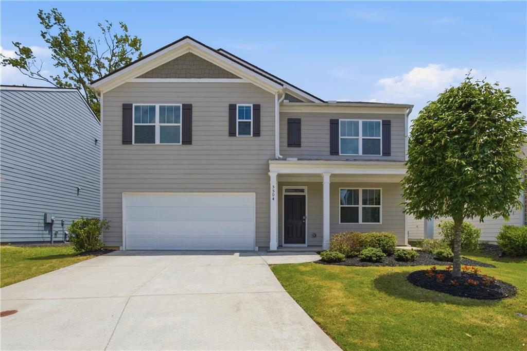 Two-story home with a two-car garage, covered entry, and a concrete driveway