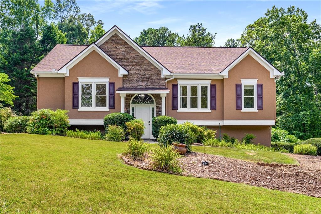 Welcome to this beautifully maintained home on a large, private lot in a quiet, friendly community just minutes from I-575, Downtown Woodstock, and The Outlet Shoppes. With hardwood floors, abundant natural light, and generous gathering spaces, this home blends everyday comfort with easy entertaining. At its heart is a true chef’s dream with two full kitchens on the main level—one with white cabinetry, the other with custom-stained wood—plus a breakfast bar, cozy eat-in nook, and view into the family room. Upstairs, the oversized primary suite features dual vanities, a whirlpool tub, and separate shower, while additional bedrooms offer excellent closet space and flexible rooms perfect for a home office, media space, or creative studio. Upstairs, a sunroom bathed in natural light provides the perfect spot for morning coffee, quiet reading, or a cozy second living space. The daylight basement serves as a full in-law suite with a private exterior entry, in-home sauna, and an oversized laundry room with space for side-by-side units, folding tables, and built-in storage, plus abundant additional storage throughout. The garage includes two finished rooms—a dedicated home gym and a separate workshop—offering space for projects and wellness without sacrificing parking. Enjoy peace of mind with a newer roof (2021) and relax in your massive, private backyard ideal for entertaining, gardening, or simply enjoying the outdoors. Thoughtfully designed and move-in ready, this home offers comfort, space, and convenience in one of Cherokee County’s most desirable locations.