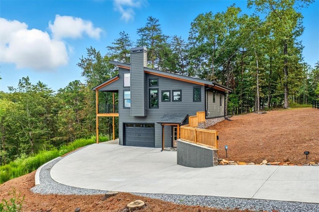 Welcome to Nature's Paradise!!! Modern Farmhouse with Panoramic Mountain Views This remarkable modern farmhouse combines timeless character with sleek, updated design, offering 3 bedrooms, 2 baths, and a versatile loft. From the moment you arrive, you'll be drawn to the eye-catching exterior and the dramatic mountain backdrop. The architecture blends crisp lines, expansive windows, and classic farmhouse accents to create a home that feels both welcoming and refined. Inside, the soaring family room is filled with natural sunlight, thanks to its elevated ceilings and carefully placed windows framing the surrounding peaks. This spacious gathering area is ideal for entertaining, quiet evenings by the fire, or simply taking in the tranquil scenery. The gourmet kitchen, highlighted by vaulted ceilings and a convenient breakfast bar, is the centerpiece of the home. Outfitted with premium finishes and modern appliances, it's designed for everything from casual meals to hosting friends while enjoying breathtaking views. Off the kitchen, another bedroom, and a full bath, perfect for guests or family seeking privacy and a loft. The main level offers two inviting bedrooms and generous closets for extra storage. A full bath and a well-placed laundry room ensure day-to-day living is effortless and stylish. This flexible space can easily serve as a private suite, home office, or recreation room, with direct access to the landscaped outdoors for seamless indoor-outdoor living. A one-car garage completes the home, offering both convenience and functionality. Most of the newly built homes in the resort do not have this feature. Other customizations added to the home after purchase cost over $25000 and make this property stand out from the neighbors. Additional customizations include a concrete driveway and retaining wall, stone on the retaining walls, a front porch, and the front of the house, and the clearing of several trees to accentuate the view. A fence, indoor blinds, accent lighting, and leaf filter gutter guards were also added. With its thoughtful floor plan, striking views, and harmonious balance of rustic charm and modern elegance, this new farmhouse delivers the perfect mountain retreat. Don't miss your chance to call it home!