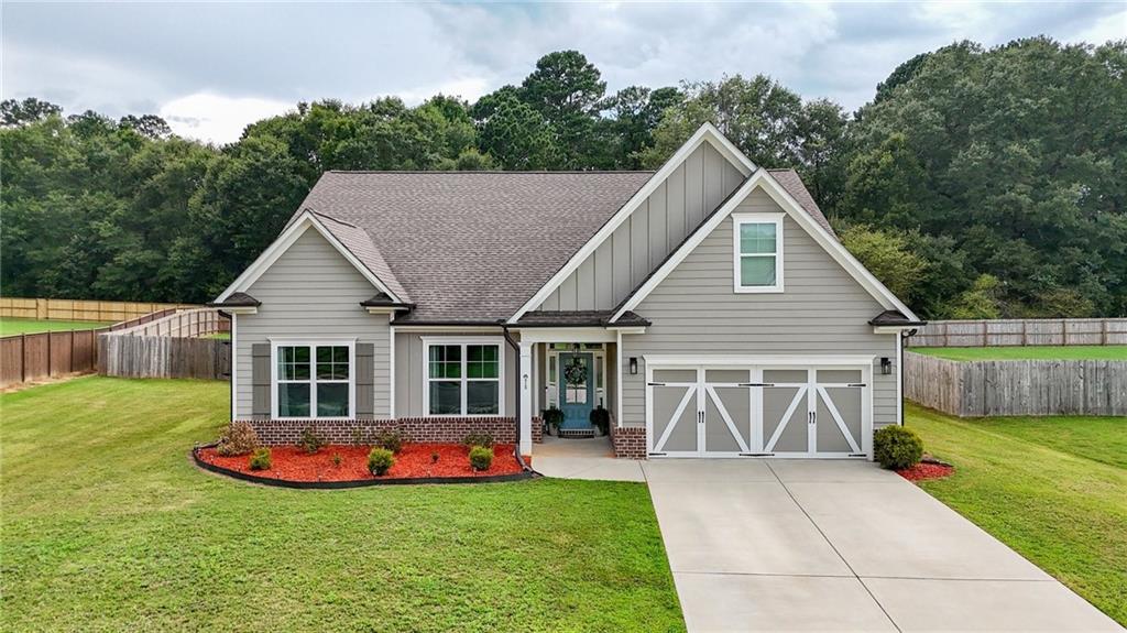 Stunning better than new Craftsman/Farmhouse on Nearly One Acre
Experience the perfect blend of timeless charm and modern comfort with The Milton Plan — a gorgeous, farmhouse-style ranch designed with your family in mind. Nestled on a generous, nearly one-acre homesite in the sought-after Dunagan Farms subdivision, this beautifully crafted home offers exceptional quality, spacious living, and unbeatable convenience.
As you approach, you'll fall in love with the eye-catching curb appeal, featuring durable Hardiplank siding, classic brick accents, and a welcoming front porch that sets the tone for what’s inside.
Step through the front door and into a light-filled, open-concept layout where a soaring vaulted ceiling adds a dramatic flair to the warm and inviting family room. Gleaming luxury vinyl plank flooring flooring flows seamlessly throughout, creating a sense of elegance and durability.
The chef-inspired kitchen is a true showpiece — complete with sleek granite countertops, custom cabinetry, designer lighting, and a massive center island ideal for entertaining or casual family meals. Enjoy uninterrupted views into the family room, allowing you to stay connected with loved ones while preparing your favorite meals.
Retreat to the spacious and serene primary suite, featuring a spa-like en-suite bath with a luxuriously oversized soaking tub, perfect for unwinding after a long day. Or enjoy a late night beverage or morning coffee on your private back patio overlooking the large, flat fenced-in yard.
Built with energy efficiency in mind, this home includes Jackson EMC’s Right Choice features, delivering year-round comfort and lower utility bills.
All of this is set in a prime location—just minutes from top-rated schools, convenient shopping, and quick access to Highway 316, making your daily commute a breeze.
This exceptional home combines style, space, and smart design — and it won’t last long.