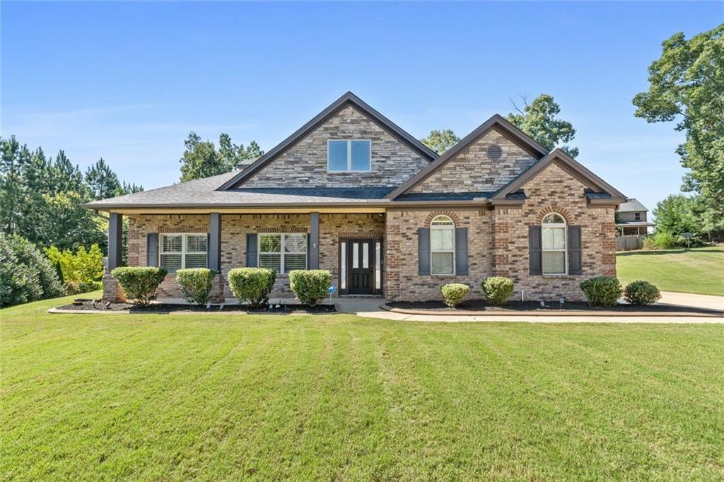 Prestigious Living in a Gated Community! Step into elegance inside this sought-after gated neighborhood, complete with resort-style amenities including a sparkling swimming pool and tennis courts. Offering charming Curb Appeal, relax on the inviting rocking chair front porch before stepping inside the front entrance with soaring ceilings. With entertainment at it's best, this spacious family room features a cozy fireplace and a built-in surround sound theater system with 1100-watt speakers, plus outdoor speakers on the covered back patio (all included!). At the heart of the home, the kitchen boasts with updated quartz countertops, a massive island, a breakfast bar for six, walk-in pantry, brand new gas cooktop, double ovens, pot filler, and deep sink, all designed for both function and style. This is a chef’s dream kitchen. Main-Level Owner’s Retreat, where you can enjoy privacy in the luxurious owner’s suite with a spa-like bathroom featuring a jacuzzi tub, separate shower, double vanities and a large walk-in closet. Two additional vaulted-ceiling bedrooms are located on the main, tucked away for comfort. Upstairs is the wow-factor. A private suite awaits with its own oversized bedroom, full bath, walk-in closet, and a bonus room perfect for a media room, man cave, or teen retreat. Take a look at all these included extra touches...Intercom system throughout, plantation shutters throughout, built-in laundry cabinetry with a retractable countertop fitting any size washer & dryer, fiber optics throughout, and security cameras. Outdoor living features a private backyard with a covered patio with dual ceiling fans, creating the perfect space for entertaining or relaxing. This home is perfectly positioned just down the street from Strong Rock Christian School, and minutes from the interstate, grocery stores, and an array of restaurants and shopping, this home has it all blending luxury, convenience, and security. Located in an eligible area for USDA 100% financing, making this dream home even more attainable!