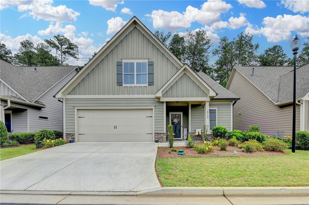 Located within a gated community, this Craftsman-style home features an owner's suite and guest bedroom on the main level, The Property boasts numerous upgrades, including wide plank hardwood floors, crown molding, and square vanity sinks with tile floors in the bathrooms. The Kitchen, showcased in the open floor plan, features designer cabinets with soft-close doors and drawers, stainless steel appliances, granite countertops, an under mount stainless steel sink, and a tiled backsplash. The great room offers an open concept with a fireplace and gas logs, the owner's suite is equipped with a luxury bath, featuring dual vanities, granite countertops, an oversized shower, and a spacious walk-in closet. Additional highlights include a private guest bedroom with en-suite bath, storage, and two-inch blinds on all the windows. A private sunporch is accessible from the great room or owner's suite. The residence also features a two car garage with a carriage-style garage door. This gated community, designed for residents 55 and over, offers a clubhouse, outdoor seating area and guest parking.