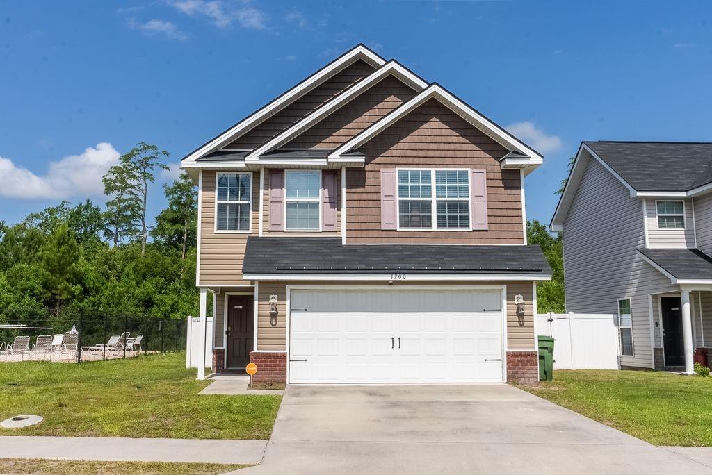 Craftsman-style house featuring concrete driveway, an attached garage, and brick siding