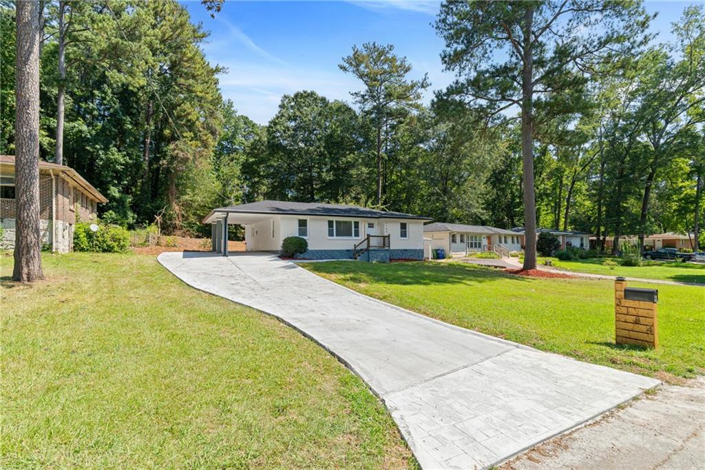 Welcome to 3184 Pinehill Drive, a Fully Renovated and Expanded Bungalow on a super quiet street in Decatur! This Gorgeous 3 Bedroom, 2 Bathroom single story home seamlessly blends Modern Updates with Timeless Charm. As you step inside the home, the first thing you will notice is the Open Floor filled with tons of natural light and refinished hardwood floors throughout. The Living Room is located to the left and flows nicely into the Kitchen and Breakfast Area towards back of home. Kitchen features White Shaker Cabinets with soft-action close doors and drawers, Quartz Countertops, Island with Breakfast Bar and a Full Suite of Stainless Steel Appliances. Laundry Room is located just off the Kitchen near the back entry door. The Primary Suite is tucked away in the back of the home for privacy. Spacious Primary Bedroom with Recessed Lighting, Tons of Light, Generous Walk-In Closet and Direct Access to Deck overlooking the backyard. The Ensuite Bathroom features a large Shower with Sliding Glass Door and Double Vanity. The Secondary Bedrooms are located on the right side of the home and share a convenient Secondary Bathroom, making this home perfect for families or guests. Brand New Roof, Water Heater and Furnace. Brand New Concrete Driveway with ample off-street parking for at least 4+ vehicles. Walk-In Crawlspace great for Storing Lawn Tools or Additional Storage. Property has easy access to I-285, I-20 as well as Downtown Decatur and Avondale Estates for all your Restaurant, Shopping and Entertainment.