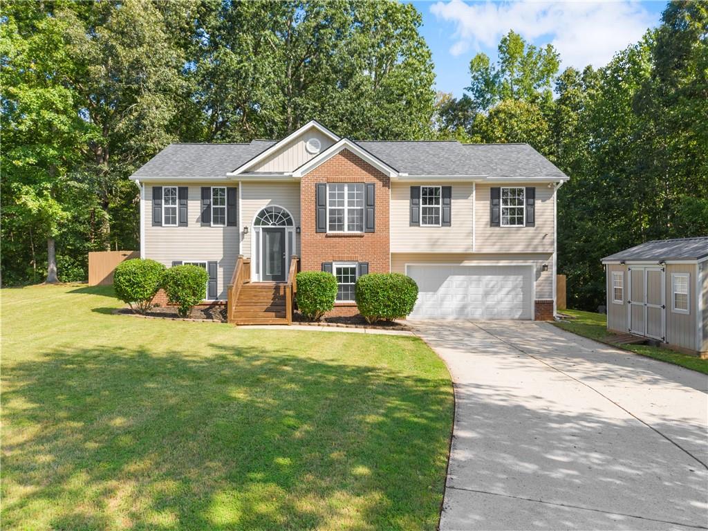 Welcome to this beautifully updated and expansive split-level home, perfectly nestled on a quiet, wooded cul-de-sac lot spanning over an acre in a non-HOA community! This move-in ready gem offers the ideal blend of space, comfort, and modern upgrades — inside and out. Step inside to discover fresh interior paint and brand-new flooring. The heart of the home features an open-concept eat-in kitchen with stainless steel appliances and flows seamlessly into the large, light-filled living room with vaulted ceilings, a cozy fireplace, and access to the oversized covered back deck overlooking your private backyard oasis. Formal dining room perfect for entertaining. Retreat to the spacious master suite featuring tray ceilings, plush new carpet, double vanities, separate shower and soaking tub, and updated vinyl flooring. Two additional bedrooms and another full bath complete the upstairs. The lower level offers incredible flexibility with a fourth bedroom, full bath, and a versatile bonus room or potential 5th bedroom — ideal for guests, a home office, or playroom. Plus, enjoy the convenience of a finished storage room behind the garage for all your extras. Additional highlights include: Newer roof, HVAC systems, and water heater. Septic tank pumped (August 2025). New gutters (2023). Comcast security system with 4 cameras, 2 keypads, motion sensor & door sensors – all included. Two larger storage buildings are included as well! With plenty of room to grow, entertain, or simply relax in nature, this Barrow County beauty checks every box. Schedule your tour today and make this home your own!