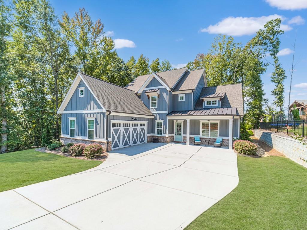 You will love this stunning Hillgrove Homes resale in the sought-after Traditions of Braselton community. This home is beautiful from the front door to the back yard. The 8-foot entry doors that are mirrored in the formal living/dining room create such a statement. 10-foot ceilings on the main level, and 9-foot ceilings upstairs. That front flex room would make a great formal dining room, home office, or music room, and you will love the custom floor-to-ceiling wall trim. The great room, kitchen, and farmhouse-sized breakfast room create the perfect entertaining space. The kitchen has double ovens, microwave, dishwasher, gas cooktop, venthood, large island, tons of white cabinets, and granite countertops. The main living spaces feature durable Revwood Flooring. The primary bedroom on the main is spacious with high trey ceilings, and a custom board and batten wall treatment behind the bed. The primary bath is beautiful, with double vanities with granite tops, beautiful tile floors, and oversized walk-in shower that the builder called a Super Shower. Huge walk-in closet. Mud room is across from the oversized laundry, with ample cabinets and a sink. The walk-in pantry is perfection. Butler's pantry with a beverage fridge, prep sink, cabinets and shelves would make a perfect coffee bar. 3 bedrooms and 2 full baths upstairs, plus an extra-large bonus room that is currently a billiards room. The covered back porch with gas fireplace is the perfect place for fall Saturdays watching football. The yard is wooded, with plenty of privacy, and the sellers just invested a good amount of money landscaping the yard with new plantings. This large home is a perfect place to move to in this sought-after golf community. Swim/Tennis/Pickleball and Playgrounds in the community.