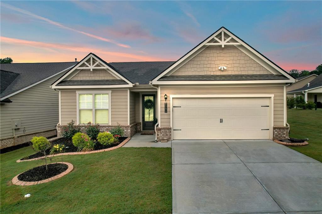 Welcome to 2292 Knob Creek Rd in the vibrant Saddlebrook 55+ community! This four-year-young, one-level home offers an open-concept floor plan with soaring 12-foot ceilings throughout—and a stunning 14-foot ceiling in the living room, complete with a cozy, single-switch gas fireplace. From the moment you step through the impressive 10-foot front door, you’ll appreciate the light-filled, spacious layout that’s ideal for both entertaining and everyday living. The chef’s kitchen features granite countertops, a tile backsplash, stainless steel appliances, double ovens, a 4-burner gas stove, and a large island with breakfast bar seating. Ample cabinetry—including newly installed sliding shelves—makes storage and organization effortless. An oversized laundry room and a 2-car garage with a dedicated storage area add to the home’s functionality. The private primary suite includes separate his-and-hers walk-in closets and a spa-like bathroom with double vanities, a tiled walk-in shower, and a private water closet. Step outside and enjoy your fully fenced backyard with a fruit-bearing peach tree, a covered patio with privacy shades, and an enclosed all-weather sunroom—perfect for year-round relaxation. Community amenities include: swimming pool, pickleball and bocce ball courts, walking trails, lake, dog park, and year-round lawn maintenance. Conveniently close to shopping, dining, and medical facilities, this move-in ready home is a must-see for those seeking space, comfort, and an active lifestyle in a prime Snellville location. Up to $24,000 in Down Payment assistance available to qualified Homebuyers through Preferred Lender!