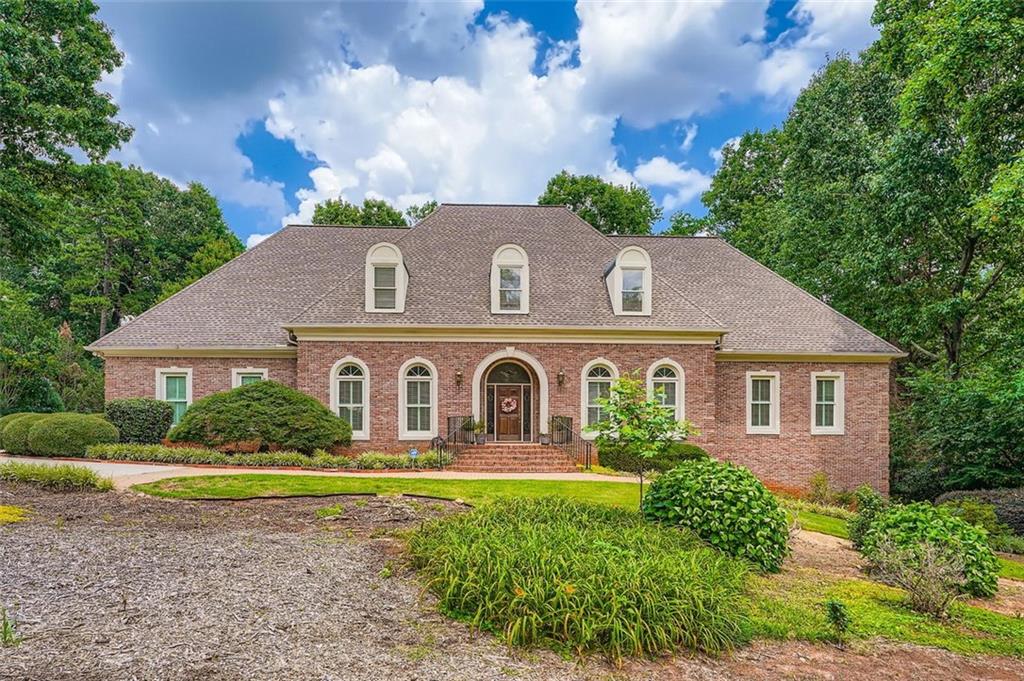 This stately four-side brick executive home in sought-after Spencers Mountain subdivision of Smoke Rise offers generously sized rooms and the convenience of two bedrooms on the main level.
The main level features an oversized primary suite with walk-in closets, a garden tub, double vanity, and separate shower, plus a second bedroom with an en suite bath. Enjoy gracious entertaining in the formal 12-seat dining room, separate formal living room, and the vaulted two-story great room, which opens via French doors to a screened porch and expansive deck. The white kitchen includes an oversized island and a spacious dining area.
Upstairs, two additional bedrooms with walk-in closets are connected by a Jack-and-Jill bath. The massive walkout daylight basement provides flexible living space, including a multipurpose room, potential theater, and a full in-law suite complete with second kitchen, bath, and private entry. A three-car, side-entry garage adds to the home's functionality.
Situated on a 0.75-acre lot, this elegant residence is just minutes from downtown Stone Mountain, downtown Tucker, Stone Mountain Park, Emory University, and Emory/DeKalb hospitals—offering the perfect blend of close-in convenience and small-town charm.