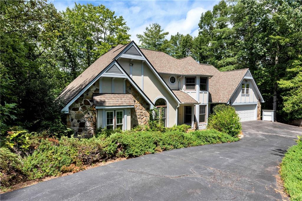 Located in the desirable gated Innsbruck Golf & Resort community just minutes from downtown Helen, this active short-term rental offers both charm and income potential. Innsbruck features top-tier amenities including golf, tennis, a community pool, on-site fine dining at the Valhalla Resort & Spa—making it the perfect blend of mountain living and resort convenience. This spacious multi-level home offers a functional layout with room for everyone. The main level includes a cozy living room with hardwood floors, a stone fireplace with wood-burning stove, and access to the back deck with hot tub and screened-in porch for year-round enjoyment. The kitchen features oak cabinetry, granite countertops, and an electric cooktop, with a dedicated dining room, laundry room, and a full bath with shower just off the kitchen. The primary bedroom on the main offers a soaking tub, separate shower, double vanities, and a large walk-in closet. An additional main-level bedroom features dual closets. Upstairs you'll find two more bedrooms—one with a flexible bonus room, perfect for a sitting room or additional bedroom—and a full bath with a shower/tub combo. The basement level includes two additional bedrooms, a full bath with a shower, and ample storage throughout. With nearly 1,200 square feet of unfinished space, there’s excellent potential to add more bedrooms or living areas—creating an opportunity to increase rental income or expand for personal use. Other highlights include a 2-car garage and low-maintenance yard. Proven STR with financials available upon request. Can be sold fully furnished, depending on terms, creating a true turn-key opportunity. This property is currently heavily booked through the end of the year, with a large portion of annual revenue generated during the last 3.5 months of the year - Helen’s popular Oktoberfest and holiday season. If the new owner chooses to honor the existing reservations, the seller is willing to work with the buyer to transfer all future bookings. Already a favorite for large wedding parties hosted at nearby Valhalla Resort, this home benefits from strong rental appeal and seasonal demand. Whether you’re seeking a personal mountain getaway or a proven income-producing investment, this Innsbruck cabin offers the perfect combination of comfort, charm, and opportunity in one of North Georgia’s most visited destinations.
