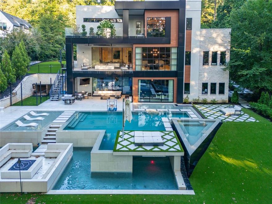 DEFINED LUXURY Awaits You in This Newly Built Contemporary Estate Home! Welcome to the pinnacle of modern luxury living in Sandy Springs just minutes to Buckhead, gated & offering exclusive luxury with ultimate privacy on every tree lined side. Designed for those who value quality, space, flow & the finest of finishes, this magazine worthy 4 Grand Bedroom, 6 (Spa Themed) Bathroom, 3 Car Garage Modern Contemporary Home includes an amazing finished terrace wonderland & breathtaking dream pool with waterfalls, spa, tanning ledges & floating walkways.  As you drive through the private tree lined gates, this home is perfectly situated far from the entry nestled upon a small hill to maximize privacy & perfectly showcase the beautiful contemporary clean lines of its stunning modern design. Prepare to be inspired & fall in love at first sight from the outside & in every room with this refreshing vision of clean lines combining a stone, stucco, metal & walnut themed exterior canvas with maximized floor to ceiling glass. From the dramatic walnut front pivot door with matching walnut accents & stunning exterior detailing, incredible steel floating stairs, soaring ceilings, extensive trim, tile & stone walls, Lutron lighting with automation color enhancements, linear diffusers, mega speakers, high ceilings with lit reverse treys, 8' doors, stunning stones & marbles throughout, designer tiles, custom floor to ceiling & floating cabinetry, refreshingly light wide plank hardwood flooring, multiple glass floor to ceiling pocket panels that open the walls to welcome you to the multiple inviting outdoor oasis, multiple decks & Zen zones, a gorgeous terrace waterfall edge bar, chilled glass wine room, top notch gym overlooking an incredible poolside paradise tree lined view, multiple offices, multiple flex & great rooms, walls of storybook floor to ceiling glass features to maximize natural light, floor to ceiling wall tiles, an incredible home theater, triple steel staircases, glass & metal railing, chef preferred appliances with expansive prep areas, double waterfall kitchen islands & hidden pantry, exquisite decorative lighting, gorgeous custom closet built-ins, hidden doors, paneled walls & so much more no detail was missed in this better than new modern luxury dream home. For those who appreciate distinctive design & finest quality, welcome to your new Atlanta resort styled, sports embraced, spa & entertainment themed home answering every want, wish & need. Featuring expansive bedroom suites with plentiful closets, breathtaking bathrooms, a culinary kitchen, multiple offices, an arcade area, filming room, finished terrace level, theater, multiple entertainment & breakfast bars, a game room, gym, multiple great rooms, a sauna, multiple Zen decks, an absolutely stunning infinity pool with waterfalls, floating walkways, tanning ledges, turfed golf practice areas, sports court, enhanced decking, a separate enclosed dog area & worry free turf rear lawn no wish or desire goes unanswered in this celebrity styled sports, recreation & wellness spa embraced home. Every convenience is at your fingertips with the best of automation, a backup generator, automated gates, quick & easy same day delivery zone, convenient access to top schools, 400, 285, 75, 85, Atlanta, Buckhead, Sandy Springs & Dunwoody, incredible entertainment & sports venues, plentiful parks & trails, foodie raved dining, fabulous shopping, minutes to St Joseph's, CHOA, Northside, Emory, GA Tech, yet sitting in picturesque gated privacy surrounded by mature trees where you can work, play, entertain & relax surrounded by tranquility. The pictures only begin to tell the story.  For those who appreciate distinctive design, finest quality & exceptional comforts, this thoughtfully designed architectural masterpiece offers unmatched elegance with dramatic designs that inspire & create the ultimate canvas for enjoying your best life. What are you waiting for?  Call for your private showing.
