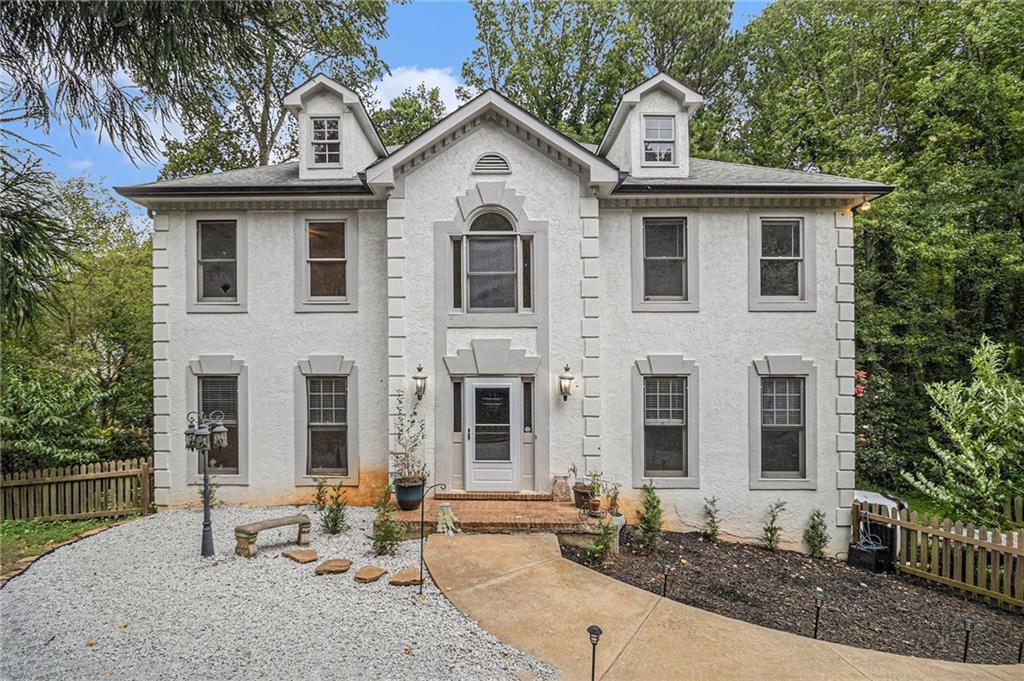 This charming traditional two-story home with a finished basement and three-car parking (including a rare tandem garage) is tucked away on a beautifully landscaped lot, offering a perfect blend of space, privacy, and convenience. The fenced front yard and wooded backyard views provide a peaceful, private setting that's hard to find. Step inside to a freshly painted interior showcasing crown molding, wainscoting, gleaming hardwood floors, and new light fixtures throughout. The formal living room and formal dining room set an elegant tone, while the inviting family room features a tray ceiling, beautifully stained built-ins flanking a classic fireplace, ad great natural light creating the perfect gathering space. The eat-in kitchen offers granite countertops, travertine backsplash, breakfast bar, along with access to the back deck for easy outdoor dining. Upstairs, the vaulted primary suite is a spacious retreat with tray ceilings, a soaking tub, walk-in shower, double vanity, and a generous walk-in closet. Three spacious secondary bedrooms, and an additional full bath accommodates guests or family with ease. The finished basement provides incredible flexibility with a media room, or potential home gym, office, or playroom—ready to suit your needs.
Outside, enjoy a backyard filled with apple, pear, fig, nectarine, peach, mulberry, apricot trees, and grapes, offering a mini orchard right at home. With leaf guard gutters, a new hot water heater, and thoughtful upgrades throughout, this home is move-in ready. NO HOA allows you to design and customize you outdoor living based on your lifestyle. Located just minutes from Kennesaw State University, top-rated schools, healthcare, shopping, dining, and major highways, this home combines classic charm with modern convenience in one of the area’s most desirable locations. Don’t miss this one-of-a-kind opportunity!