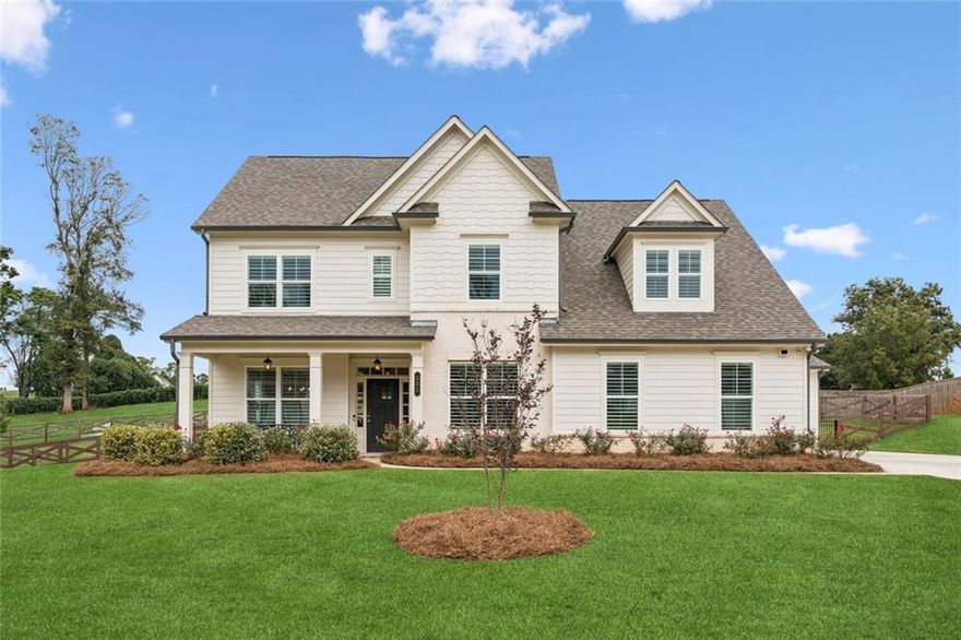 WOW! Almost a full acre, in a quiet, small neighborhood. This Is The ONE!
This “better than new” home has an Owner’s suite on the main floor AND a separate office. From the welcoming covered front porch to the timeless plantation shutters, this home is full of all the upgrades.
Inside, the foyer opens to a separate home office with crown molding and trim. A separate formal dining room with wainscoting sets the stage for those more formal or larger gatherings.
At the center of the home, the chef’s kitchen features granite countertops, designer tile backsplash, recessed lighting, soft-close white shaker cabinets, a huge walk-in pantry, and a center island with seating. Stainless steel Whirlpool appliances, including a 5-burner gas range, oven, microwave, dishwasher, and custom vent hood, make cooking a pleasure. The extra-large undermount stainless steel sink and custom pull-out trash drawer add to the functionality. The kitchen refrigerator, garage refrigerator, washer, and dryer remain. 
A bright breakfast room for your casual dining. Vaulted great room, anchored by a gas log fireplace with a raised brick hearth.
The spacious main-level owner’s suite offers vaulted ceilings and a spa-like bath with a “super shower” featuring dual showerheads. Granite double vanities with extra drawers for storage, and a totally separate makeup vanity that’s perfect for getting ready in style and comfort.  You will also find a large walk-in closet and a separate linen closet. Don’t miss the custom designer tiled flooring & shower.
Upstairs, you will find four additional bedrooms, one that’s bonus in size and has its own private ensuite bath and huge walk-in closet, making it ideal for a teen/college suite or game/rec room. Three additional bedrooms, each with walk-in closets, and two that are joined by a Jack-and-Jill bath with a separate wet area and custom tile.
Outside, the fully fenced backyard provides privacy, and a covered patio with ceiling fan, just perfect for relaxing or entertaining. 3-car garage; one double side-entry garage plus a separate 3rd carriage garage, both with epoxy floors and automatic openers. The level driveway with an extra parking pad ensures plenty of space for guests. A brick water table, sprinkler system, and landscaped yard complete the picture. The Ring doorbell with 3 cameras remain. This exceptional home, with its thoughtful upgrades and prime location, offers a lifestyle of comfort, convenience, and Southern charm.