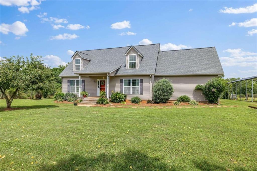 Tucked away on 2.07 fenced acres, this charming 3-bedroom, 2.5-bath home offers privacy, space, and country views in every direction. Main-level primary suite. Updates like luxury vinyl plank flooring, granite countertops, and new tile in the kitchen. Step outside to enjoy seasonal views of a nearby lake from the back deck, or pick fruit from your own trees. Surrounded by open pastureland with grazing cows, the setting is peaceful and picturesque. A 2-car attached garage and a detached 2-car carport offer plenty of room for vehicles, hobbies, or equipment. Both the roof and hot water heater are just 5 years old. Minutes from Commerce, Hwy 441, and Athens, this home combines privacy with accessibility. Note: The tax assessor's square footage is incorrect-an appraiser has confirmed the home is 1,899 square feet.