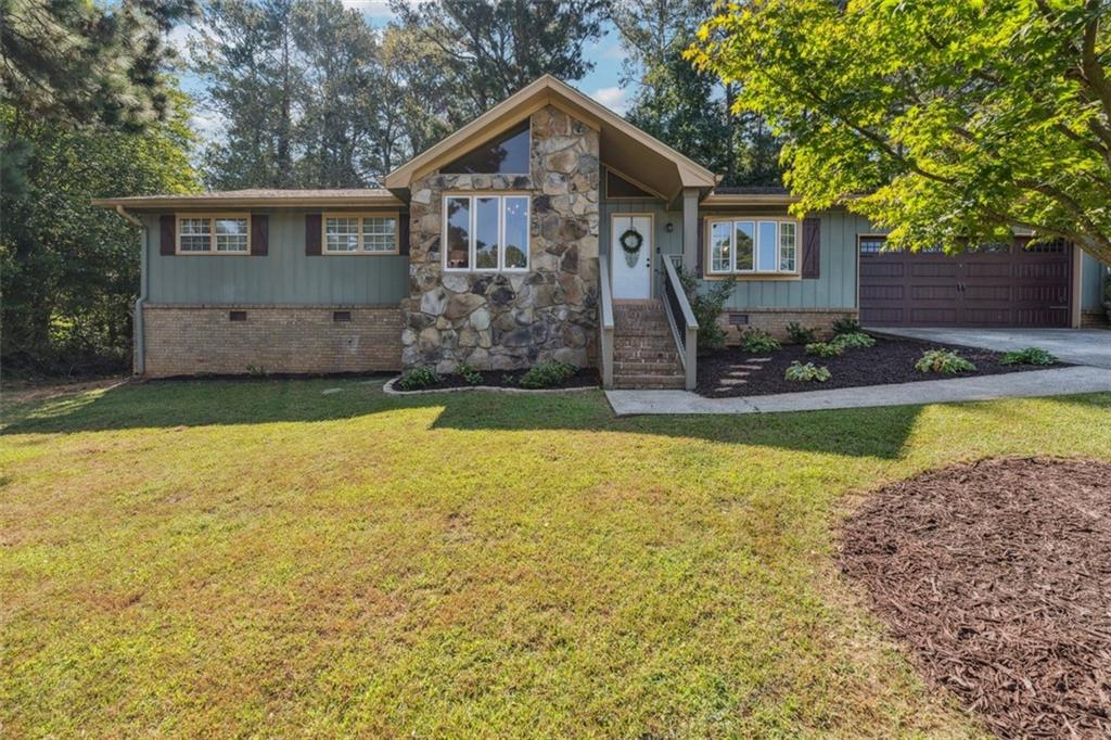 Situated on a large, wooded lot in the heart of Lawrenceville, this lovingly updated home ticks off all the right boxes! One-level living at its best, step inside to beautiful hardwood flooring, vaulted ceilings, and tons of natural light. French doors open to a dining room perfect for hosting every occasion, flanked by a living room designed for easy entertaining. The spacious kitchen has all the right updates and flows into the cozy fireside family room with access to the extended deck overlooking the lush, private fenced back yard. The serene primary suite features dual vanities and updated fixtures, and two secondary bedrooms share a second full bath. Located in the top-rated Peachtree Ridge school district, and just minutes to Lawrenceville’s Historic Downtown, Mall of Georgia, parks, and major commuter routes. Schedule your private showing today!