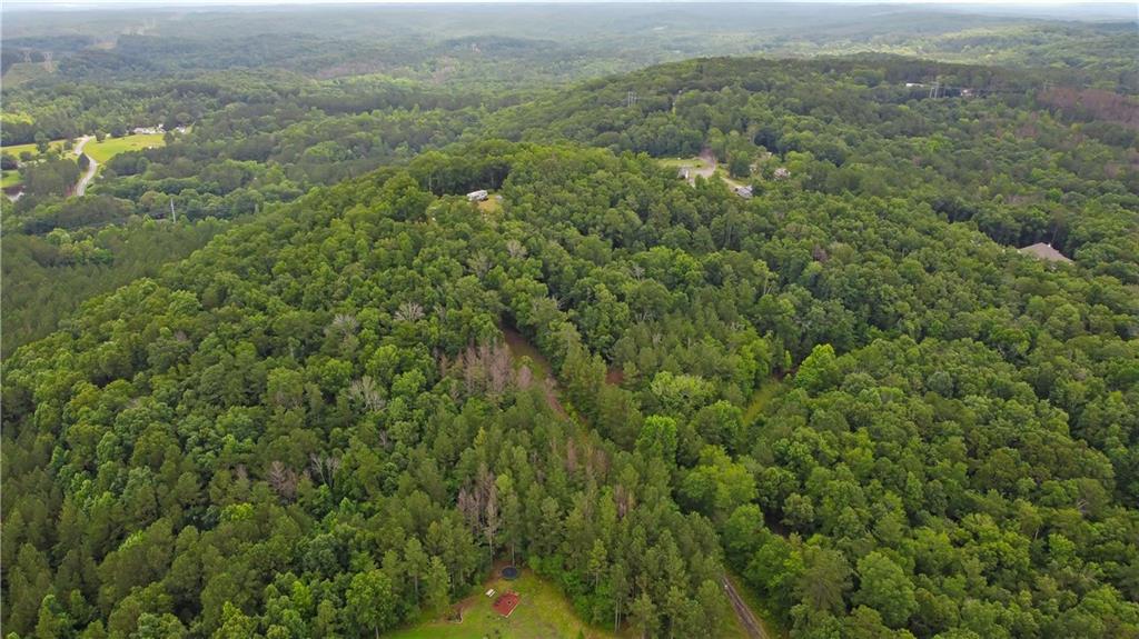A Rare Mountain-Top Retreat in North Paulding – 10 Private Acres with Panoramic Views - UNDER $200,000!!!!
Opportunities like this don’t come around often—10 acres in sought-after North Paulding is like finding a unicorn. Nestled at the end of a private drive, this expansive parcel offers the kind of privacy, peace, and natural beauty that’s increasingly hard to come by, all while being just minutes from the heart of Downtown Dallas, Cartersville, and everyday conveniences.
A couple of gently sloping, cleared acres provide the perfect setting for a custom home, with a soil study supporting septic plans. From there, the land unfolds into a stunning canvas of rolling terrain, hardwood forests, and natural rock formations. Whether you're hiking your own trails or simply enjoying the ever-changing landscape from your porch, this is the kind of property that invites you to slow down and take it all in. 10.01 Acres
Perched high above it all, this mountain-top setting delivers jaw-dropping, 360-degree views that feel more like the North Georgia mountains than suburban Dallas. You’ll experience the tranquility of being “away from it all,” without sacrificing access to modern life.
Design your dream home, weekend retreat, or forever sanctuary right here—where nature meets possibility, and the view is yours to own.
