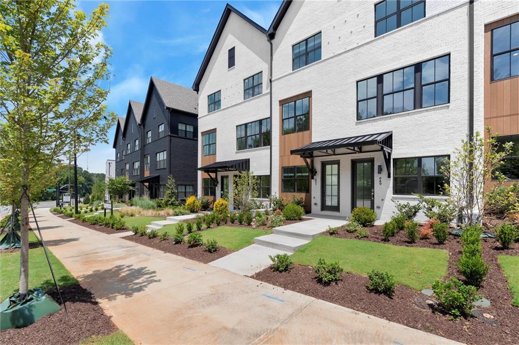 Welcome to The Anniston at The Gathering, a stunning Contemporary style townhome designed for modern living. This beautifully crafted home offers 1,644 square feet of thoughtfully designed space, features two bedrooms, a flex space, and three luxurious bathrooms, perfectly blending comfort and style. As you enter the Anniston you will find a versatile terrace level that includes a cozy flex space, a full bathroom, and convenient access to the garage. Ascend to the main living area on the second floor, where 10-foot ceilings and an open-concept layout seamlessly integrates the kitchen, dining area and living room. The gourmet kitchen showcases quartz countertops, KitchenAid appliances and maple cabinetry. This space is perfect for entertaining guests or enjoying a quiet evening at home. Step out onto the covered deck off the living area to enjoy fresh air and outdoor relaxation. The third floor is dedicated to restful retreats. The primary suite boasts a walk-in closet and a well-appointed bathroom featuring double vanities, quartz countertops and a glass shower providing a serene sanctuary. A second bedroom, complete with its own full bath, offers comfort and privacy for family members or guests. The Gathering is a vibrant new community, just minutes from downtown Alpharetta, Avalon and top-rated schools. Walk out your front door and hop right on the popular Alpha Loop. Enjoy our community amenities such as a Community Garden, Firepit and Dog Park. This home provides the ultimate modern suburban living. Experience the perfect combination of style, comfort and convenience!! This home is MOVE-IN READY!! Agent is on-site Monday, Tuesday & Saturday (10:00-6:00) and Wednesday and Sunday (1:00-6:00). Photos are a representation and design selections may vary.