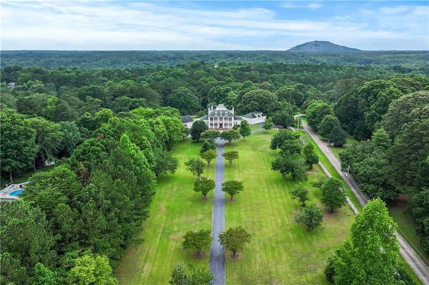 Paradise on Ross Road — where timeless elegance meets relaxed country living on nearly 7 fully fenced acres. Set behind a gated, circular drive and framed by grand columns, this private estate welcomes with a dramatic two-story foyer, Italian marble, and chandelier sparkle.

Expansive yet effortless, the residence offers seven bedrooms and refined finishes throughout—real hardwoods, rich trim, plantation shutters, and seven fireplaces. Entertain in style: a formal living/study with built-ins, a dining room that seats 12, and a soaring great room open to a sunny breakfast area and chef’s kitchen with cherry cabinetry, solid-granite counters, a massive island and dual 9-ft bars, pro-grade appliances, and gas cooktop. A large bonus room and a slate-floored sunroom extend the gathering space.

Retreat to the main-level owner’s suite with sitting area, custom fireplace, oversized closet, and spa bath; a second upper-level primary plus ensuite bedrooms provide luxe comfort for all. The finished terrace level is an entertainer’s haven with a second kitchen, bar seating, booths, game room, and spacious family room.

A separate Carriage House adds a full kitchen, bath, bedroom, living area—plus a professional music studio. Outdoors, enjoy a cobblestone patio with fire pit, lush gardens, fruit trees, and an elegant custom pool overlooking rolling pasture. No HOA. Horse-ready. Premier location.

Luxury, privacy, and freedom—your private retreat on Ross Road awaits.