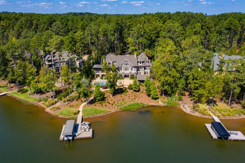 Breathtaking Lake Oconee Home situated in the exclusive gated community of Reynolds Plantation. Custom built by Dream Built and professionally decorated by Shane Meder of Black Sheep Interiors. Designed for lavish entertaining; this stunning 7 bedroom, 8 full bathroom/2 half bathroom home is as warm and inviting as it is extravagant. Greeted upon entry by an ultra impressive great room constructed with 30 ft+ high custom wooden beamed ceilings, large gourmet chefs kitchen equipped with all top of the line appliances, expansive dining area with seating for 16+, custom bunk bed room each furnished with personal reading light & privacy curtain, a surround sound home theater, temperature controlled wine cellar, and exquisitely designed 18+ seated bar. The extensive outdoor grounds yield every amenity one could desire; full-scale pristine landscaping, expansive patio with a saltwater pool & spa, upper & lower outdoor kitchens both equipped with built-in grills, and a fully covered pavilion. As you make your way down the paved pathway, cozy up to the stone fire pit or continue to the deep water dock equipped with 1 boat & 2 jet ski slips. This home has complete smart home capability controlled solely by an app. Whether home or away, at the touch of a button gain control of all lights, speaker systems, TVs, pool/spa, and security cameras. Seller is making a Club membership available.